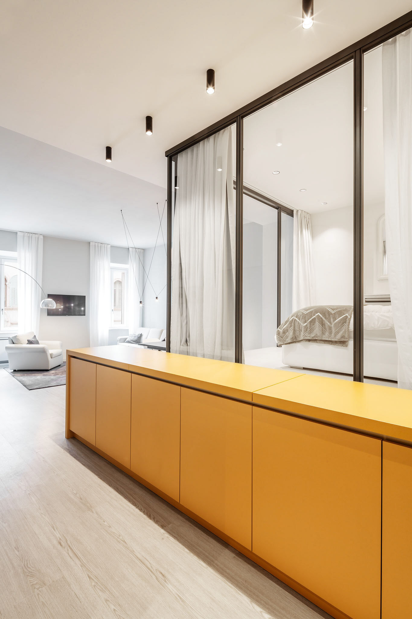A striking yellow sideboard welcomes visitors, adding personality and color while hinting at the smart design hidden within this small apartment.
