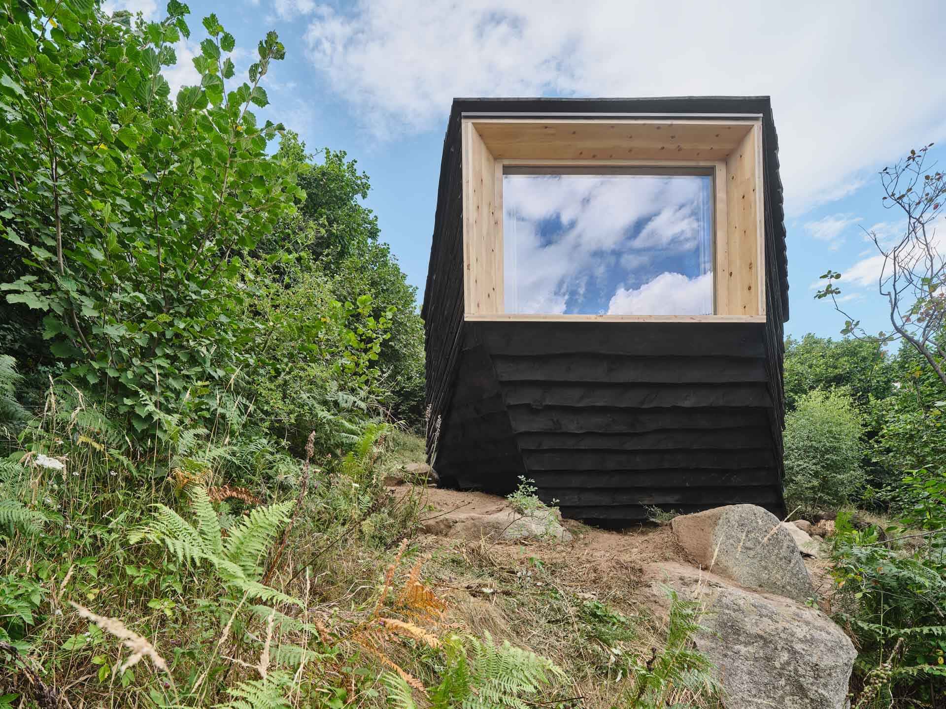 This cabin mimics the surrounding rocks while its charred timber exterior highlights fire management in the mountains.