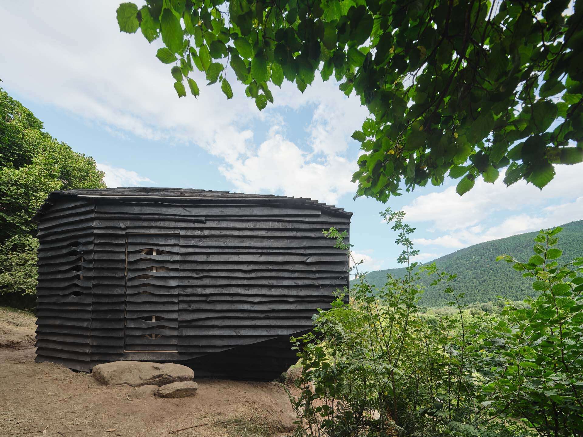 This cabin mimics the surrounding rocks while its charred timber exterior highlights fire management in the mountains.