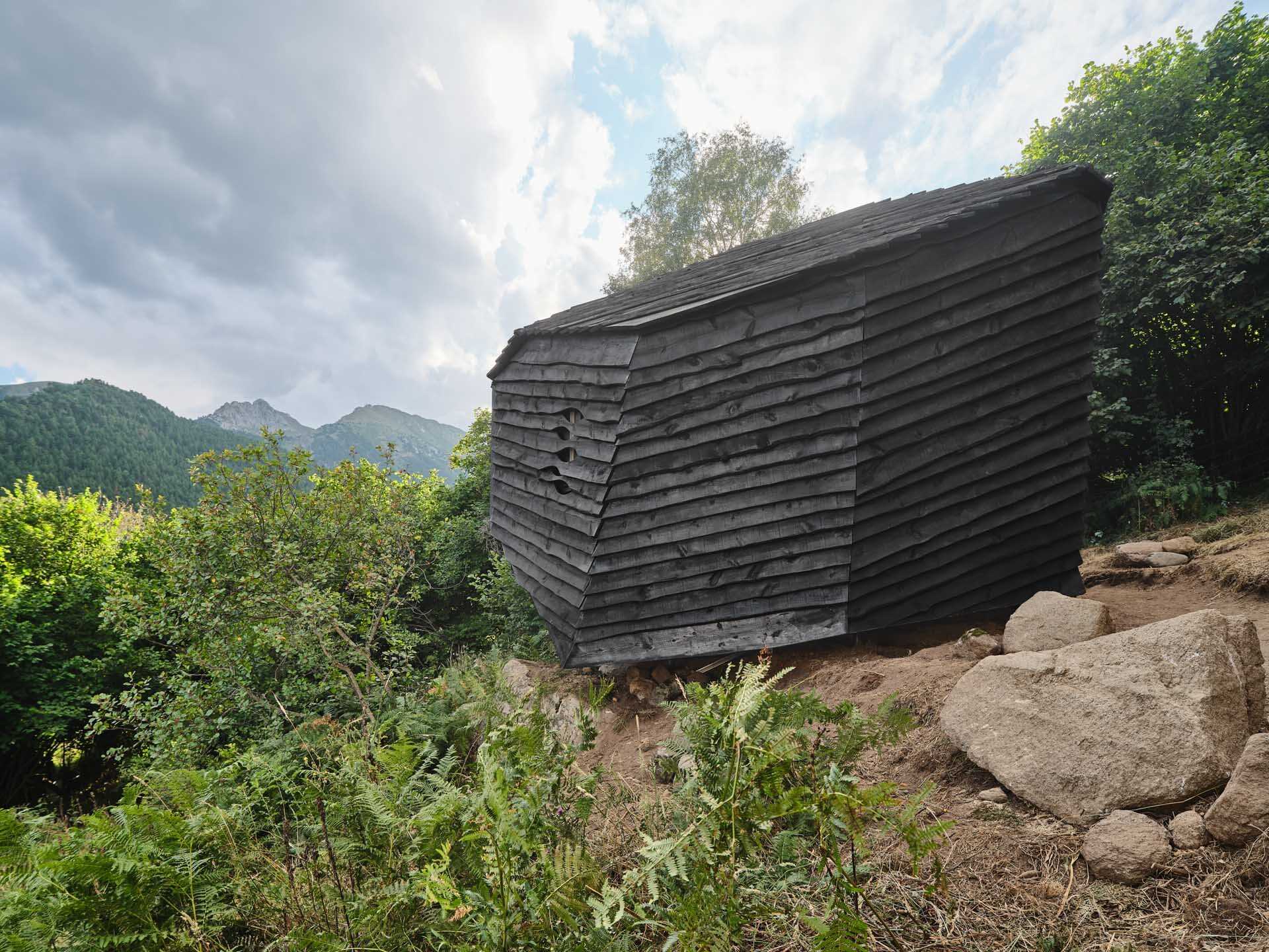 This cabin mimics the surrounding rocks while its charred timber exterior highlights fire management in the mountains.