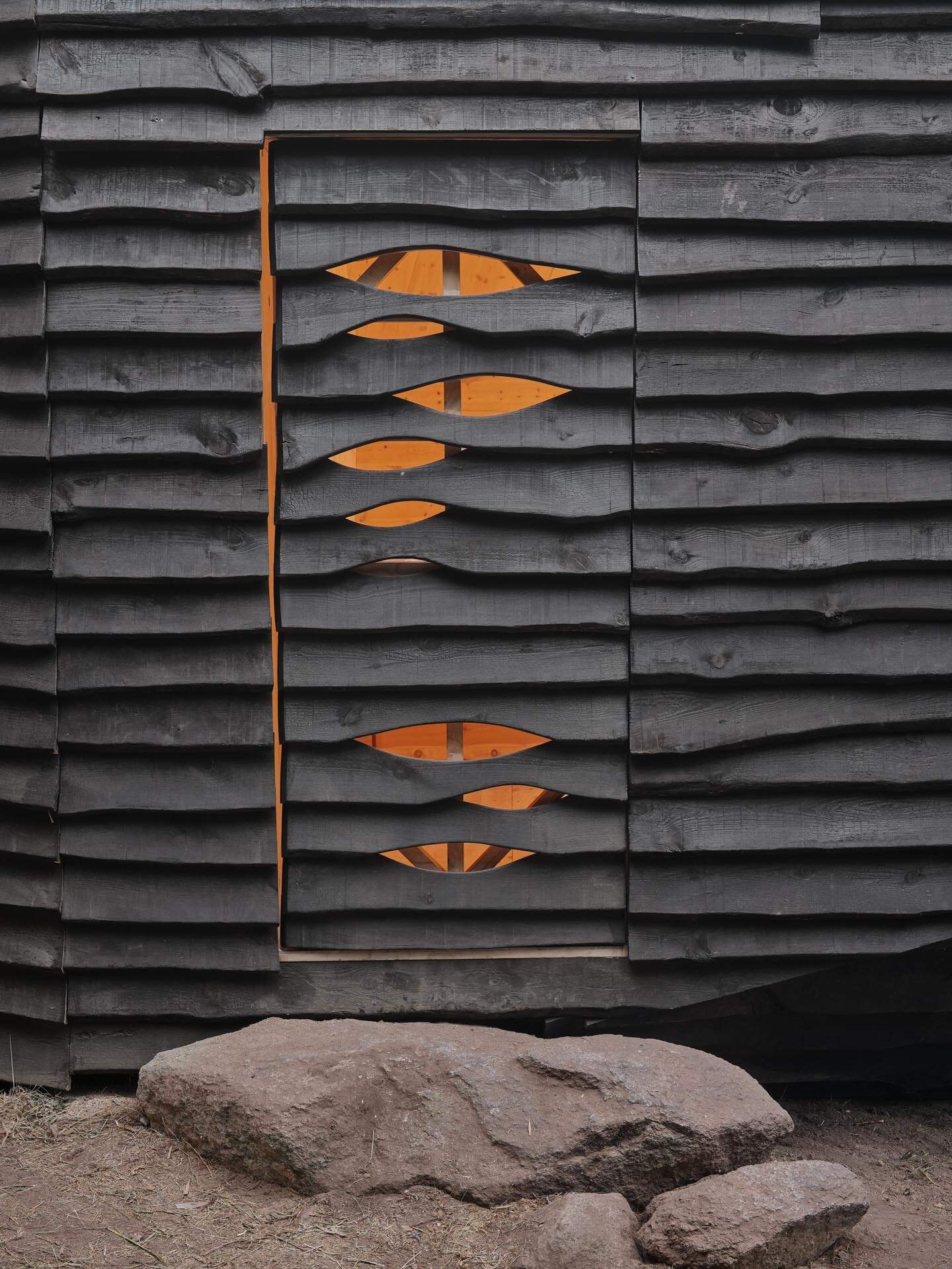 This cabin mimics the surrounding rocks while its charred timber exterior highlights fire management in the mountains.