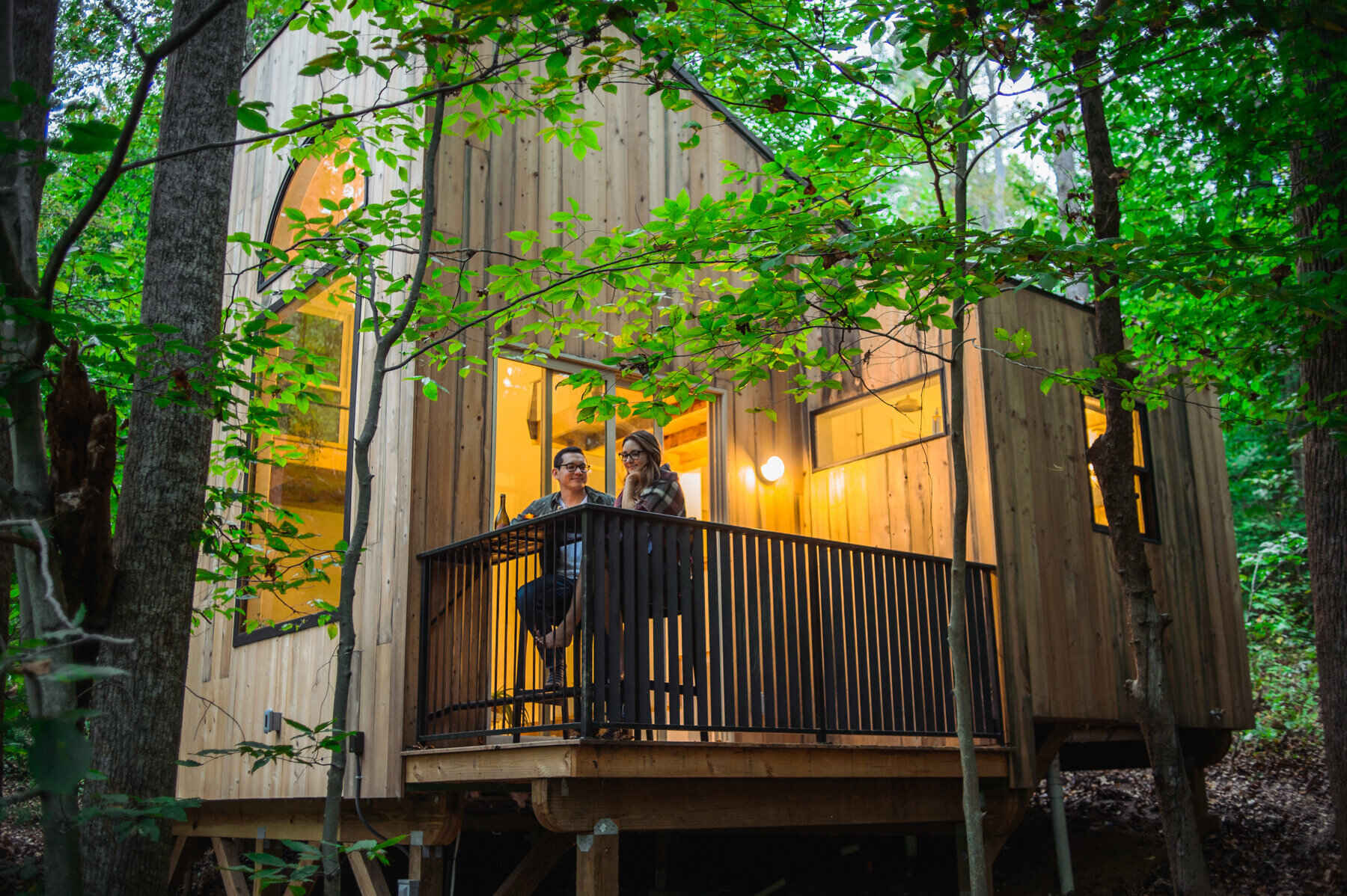 A swing by the window and a corner deck made from local lumber connect this woodland cabin to its natural surroundings, creating the ultimate slow living escape.