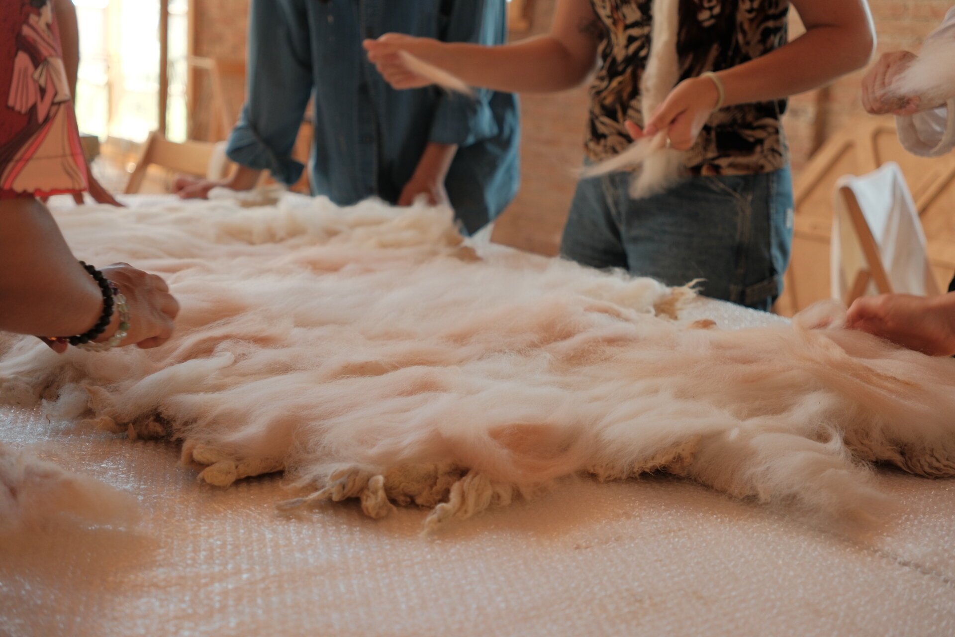 MAKING OF - Inside a small cabin, custom timber furniture, a carved stone basin, and wool textiles connect local craftsmanship with design.