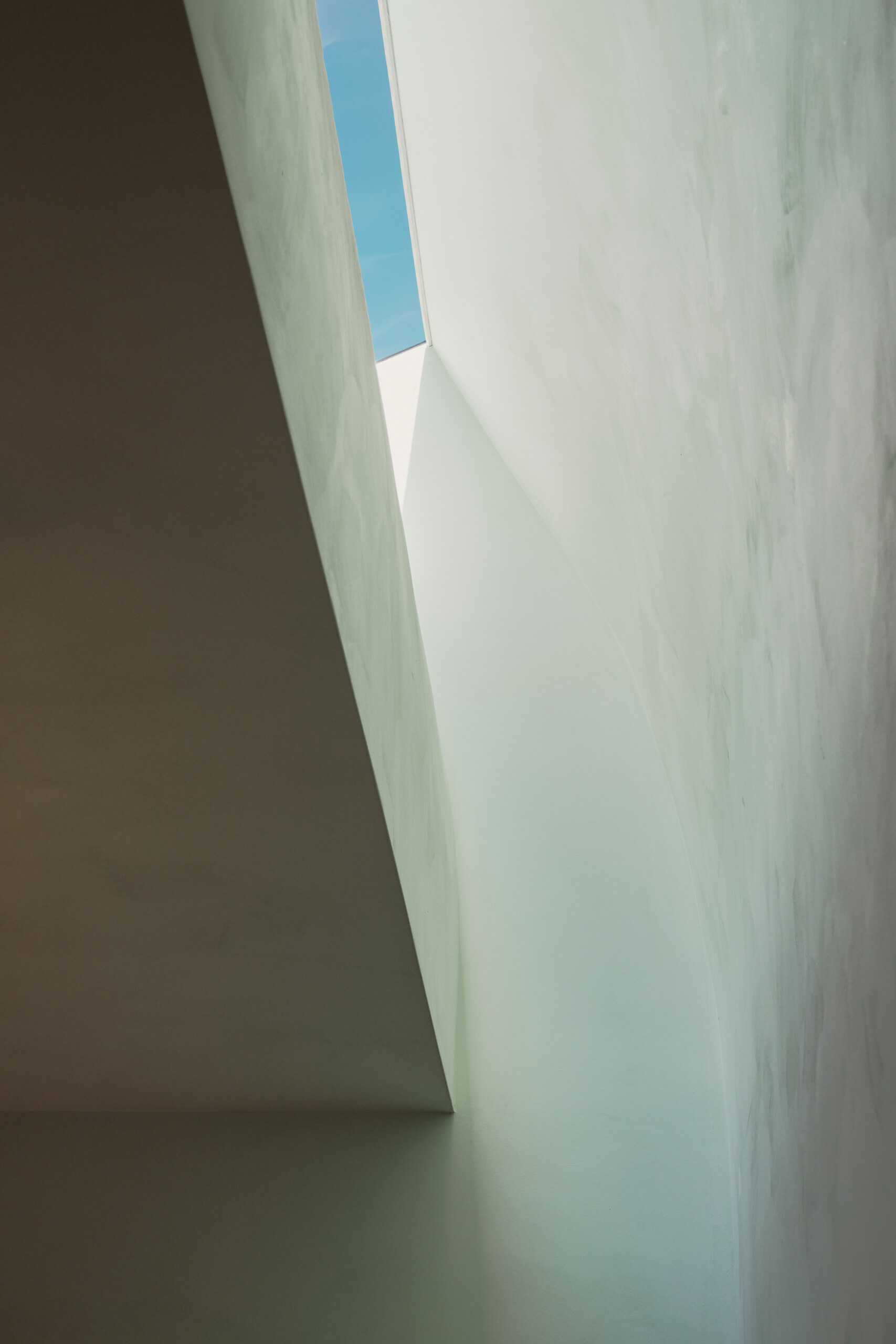 In the bedroom, a curved wall and skylight bring in shifting natural light that changes the mood throughout the day.