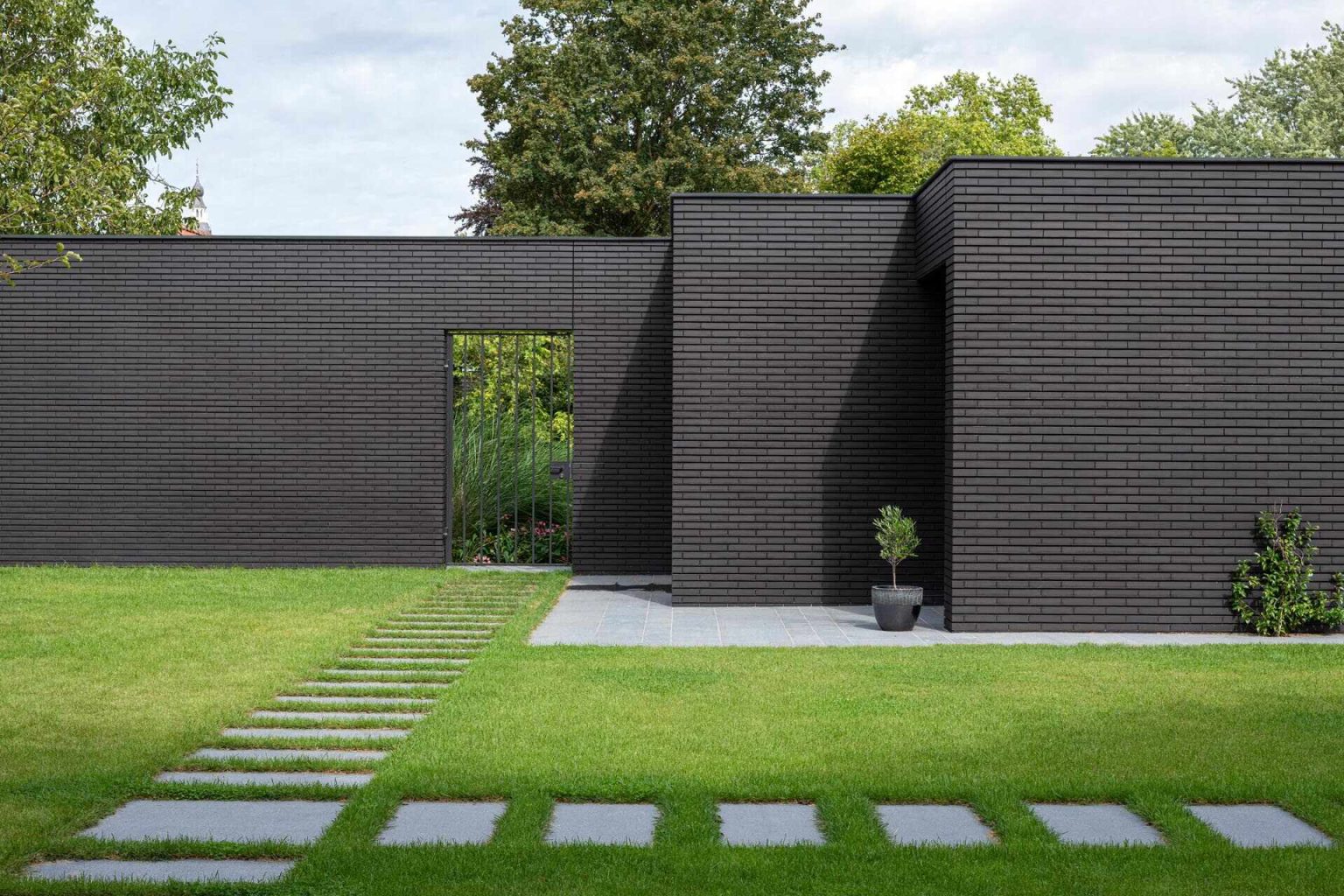 How a Bold Black Brick Exterior Hides a Calm, Wood-Filled Interior