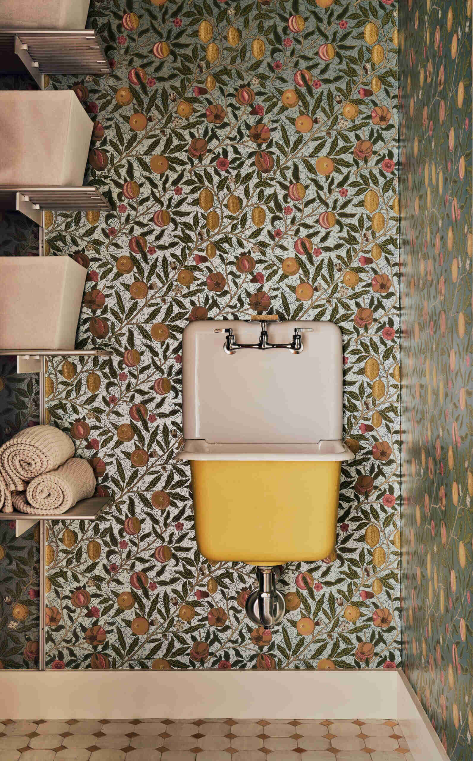 In the bathroom, expressive wallpaper adds personality and pattern, turning a small space into a bold design moment.