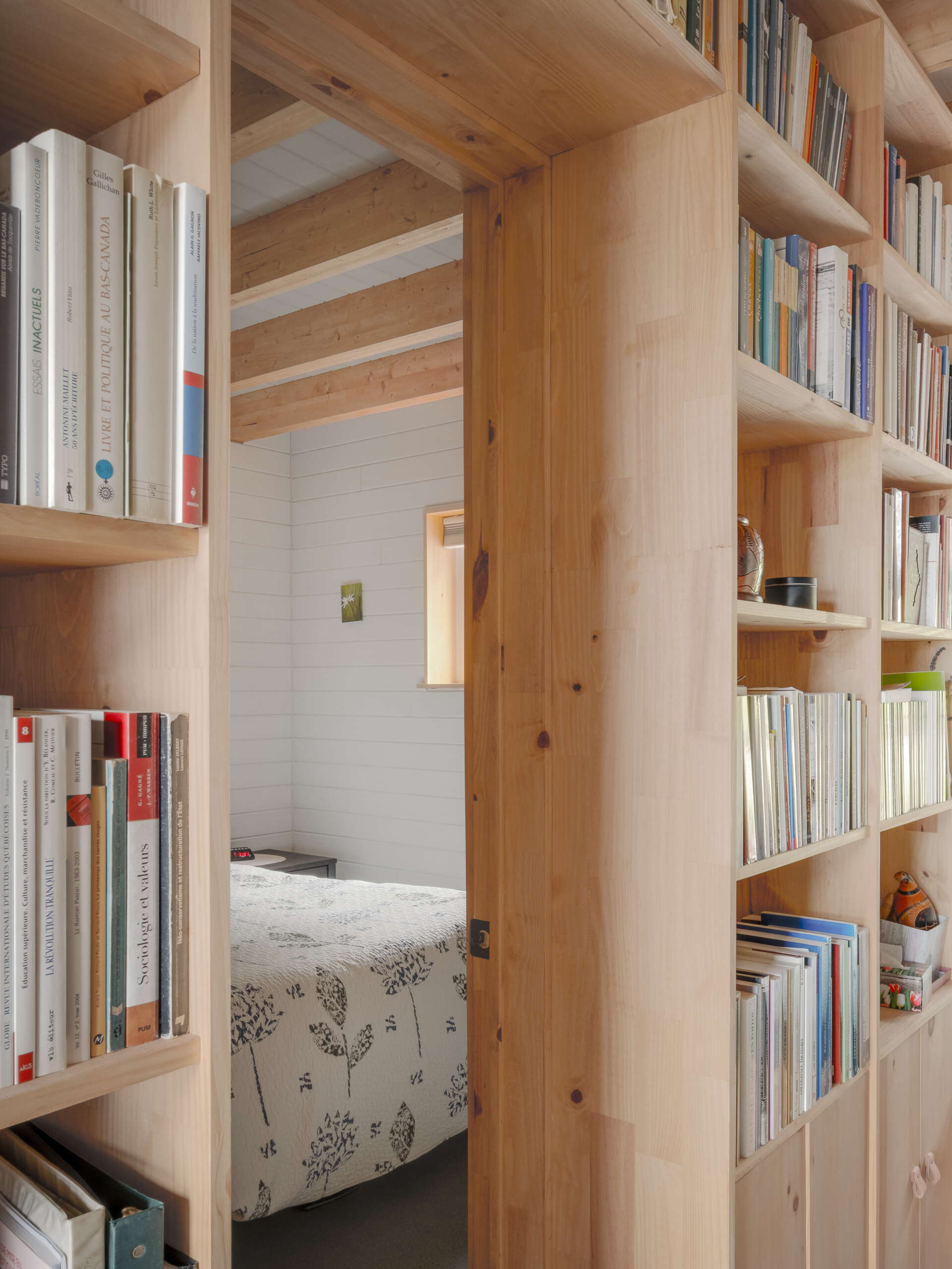 Estanterías de madera rodean la puerta del dormitorio.