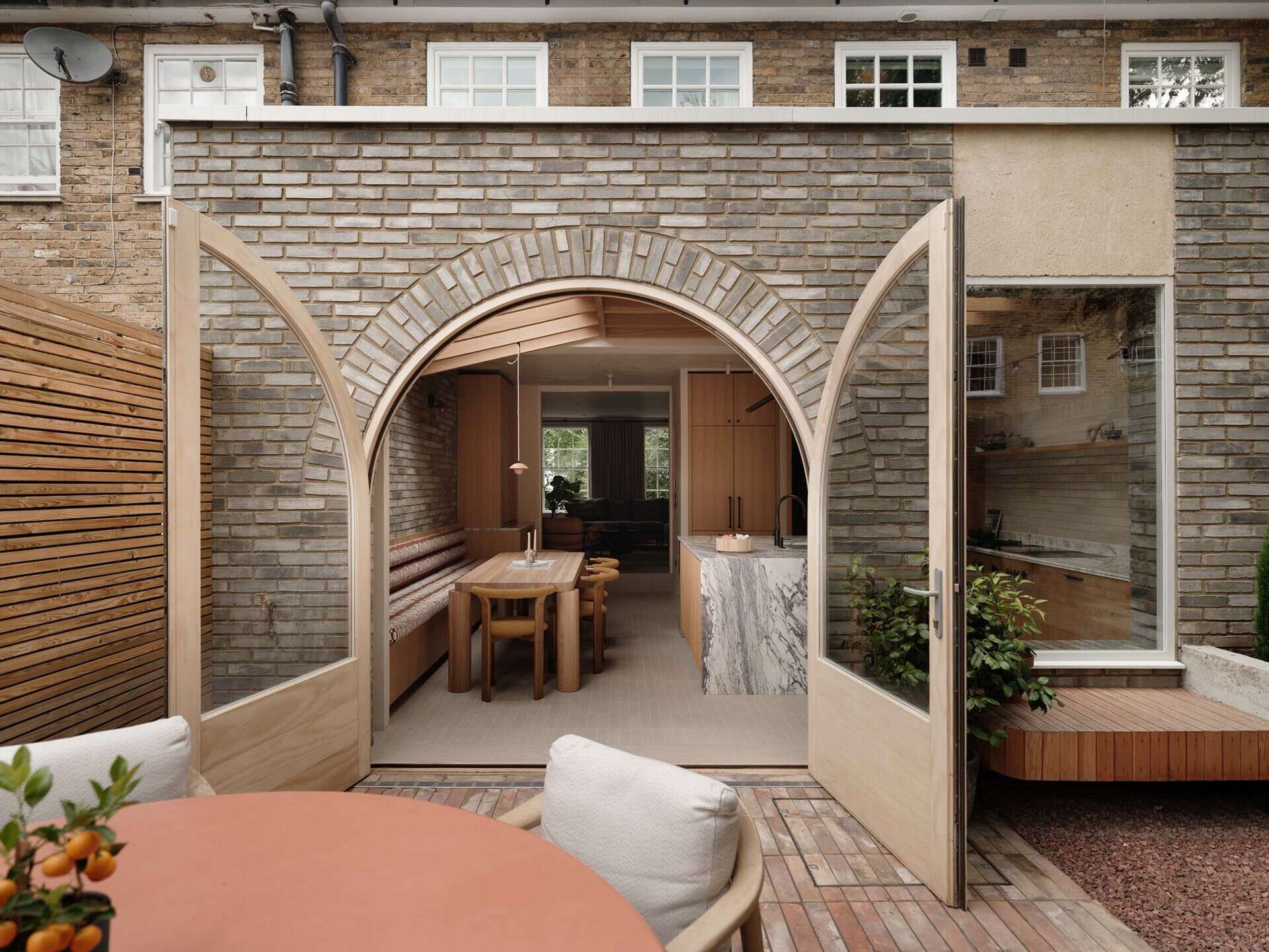 On this brick extension, arched doors and soft curves introduce a subtle architectural detail that references Georgian style while improving flow between spaces.