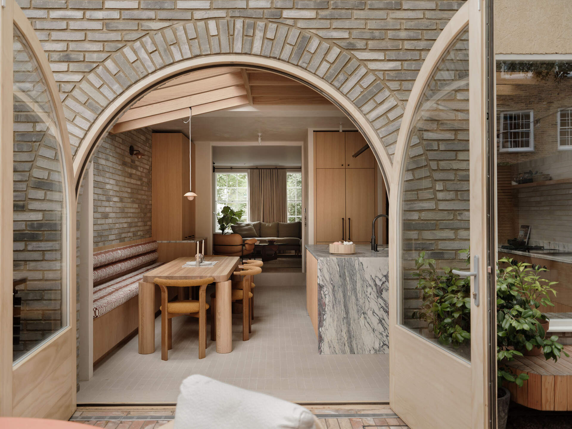 On this brick extension, arched doors and soft curves introduce a subtle architectural detail that references Georgian style while improving flow between spaces.