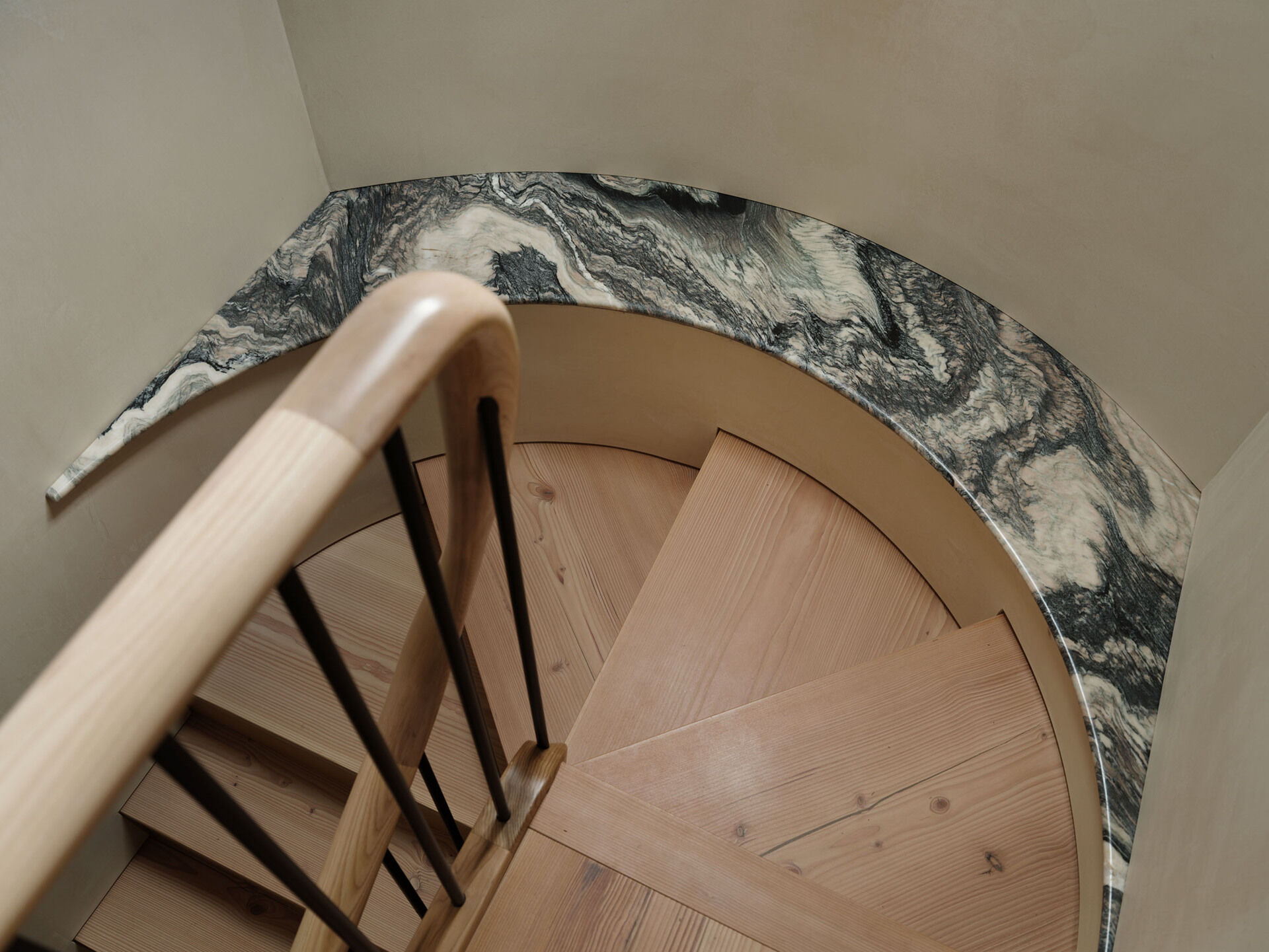 The staircase is the defining architectural element of the project. Designed as a bespoke feature with douglas fir treads and stone detailing, it rises through a three-story void. By repositioning the stair, the entrance becomes a double-height space, improving light distribution and creating a stronger connection between floors.