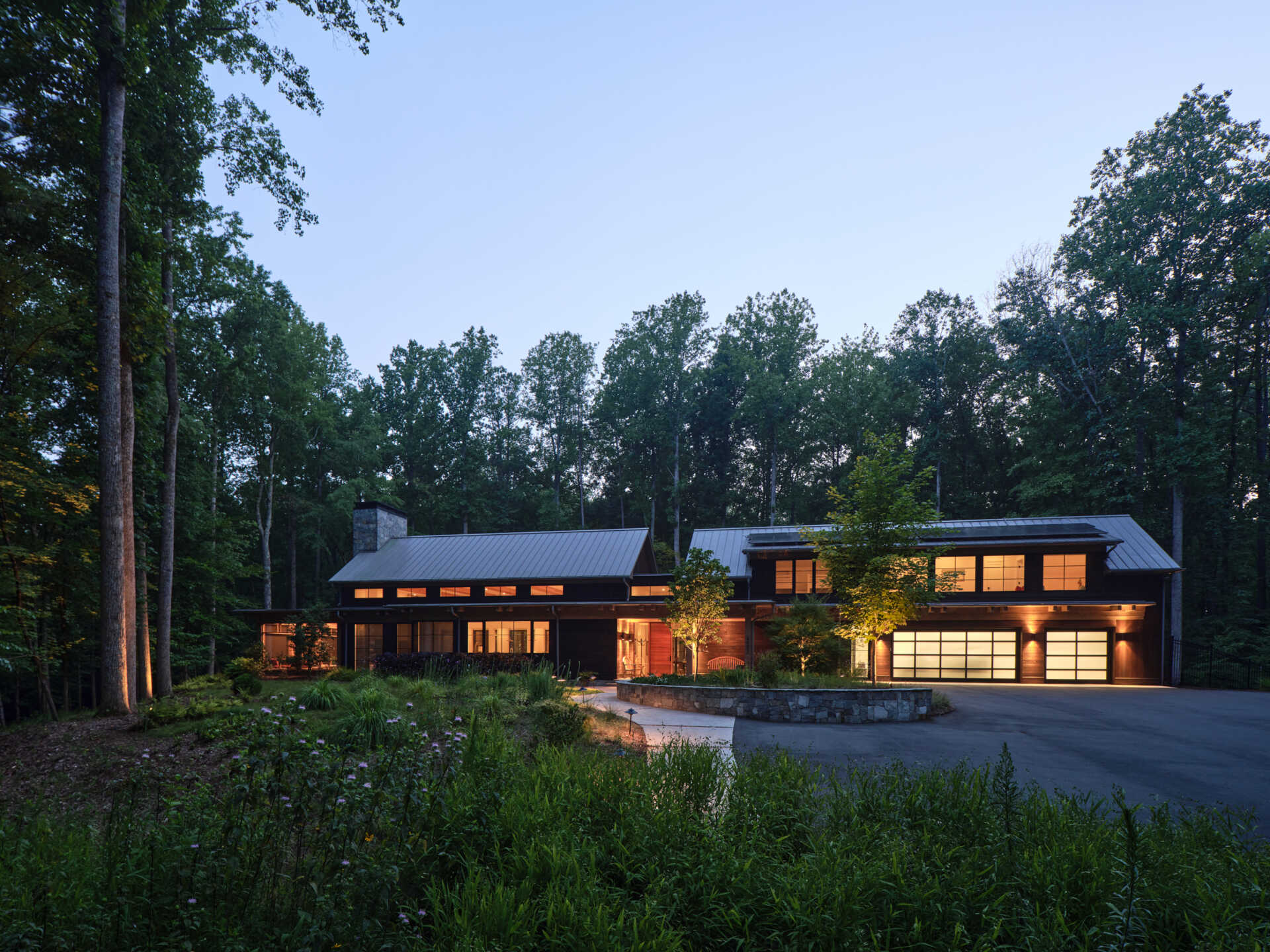 A winding forest driveway leads to this hilltop home in Duke Forest, where every arrival feels quiet and cinematic.