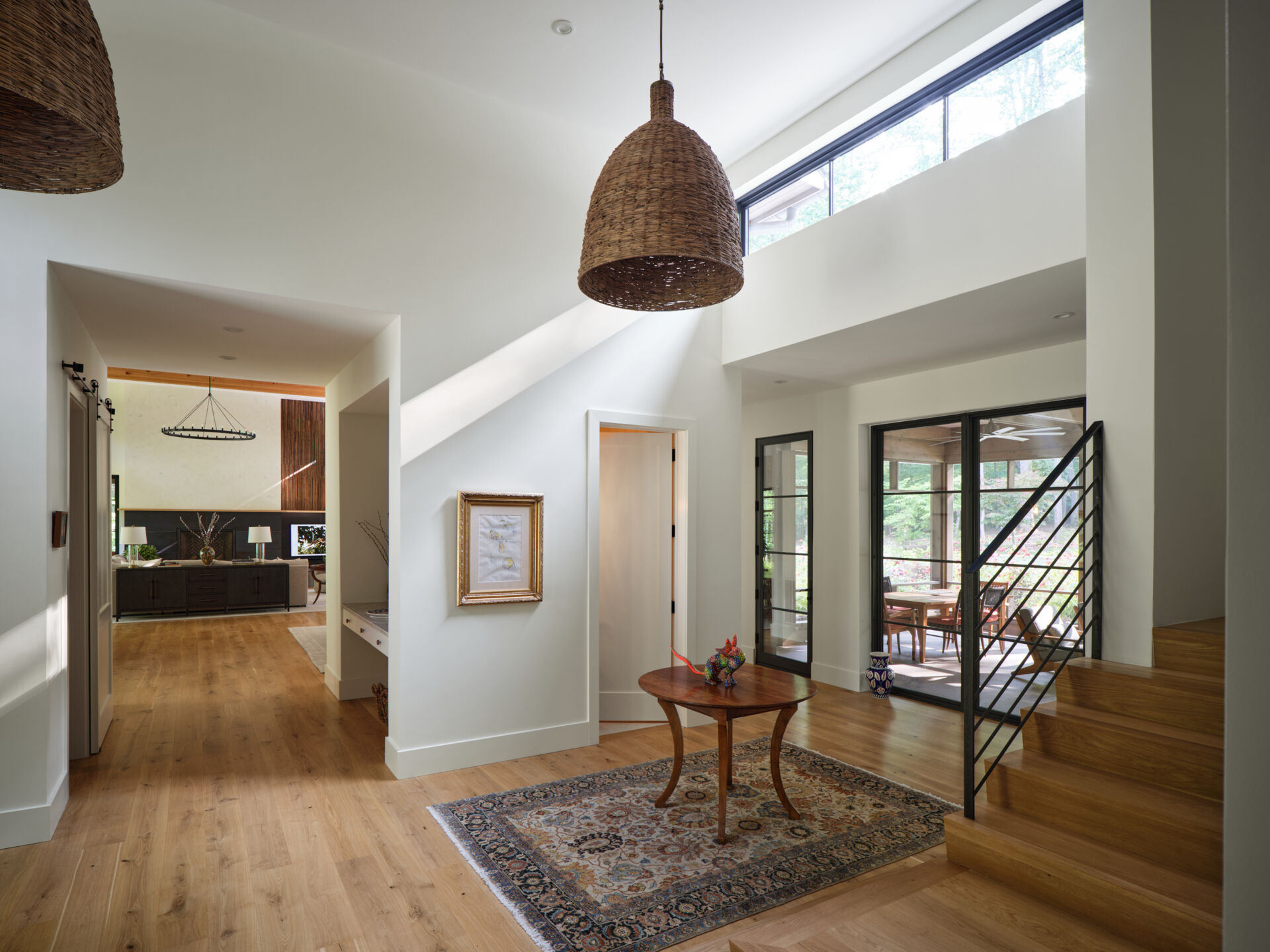 The entry opens into a bright interior with natural materials and long sightlines stretching through the home.