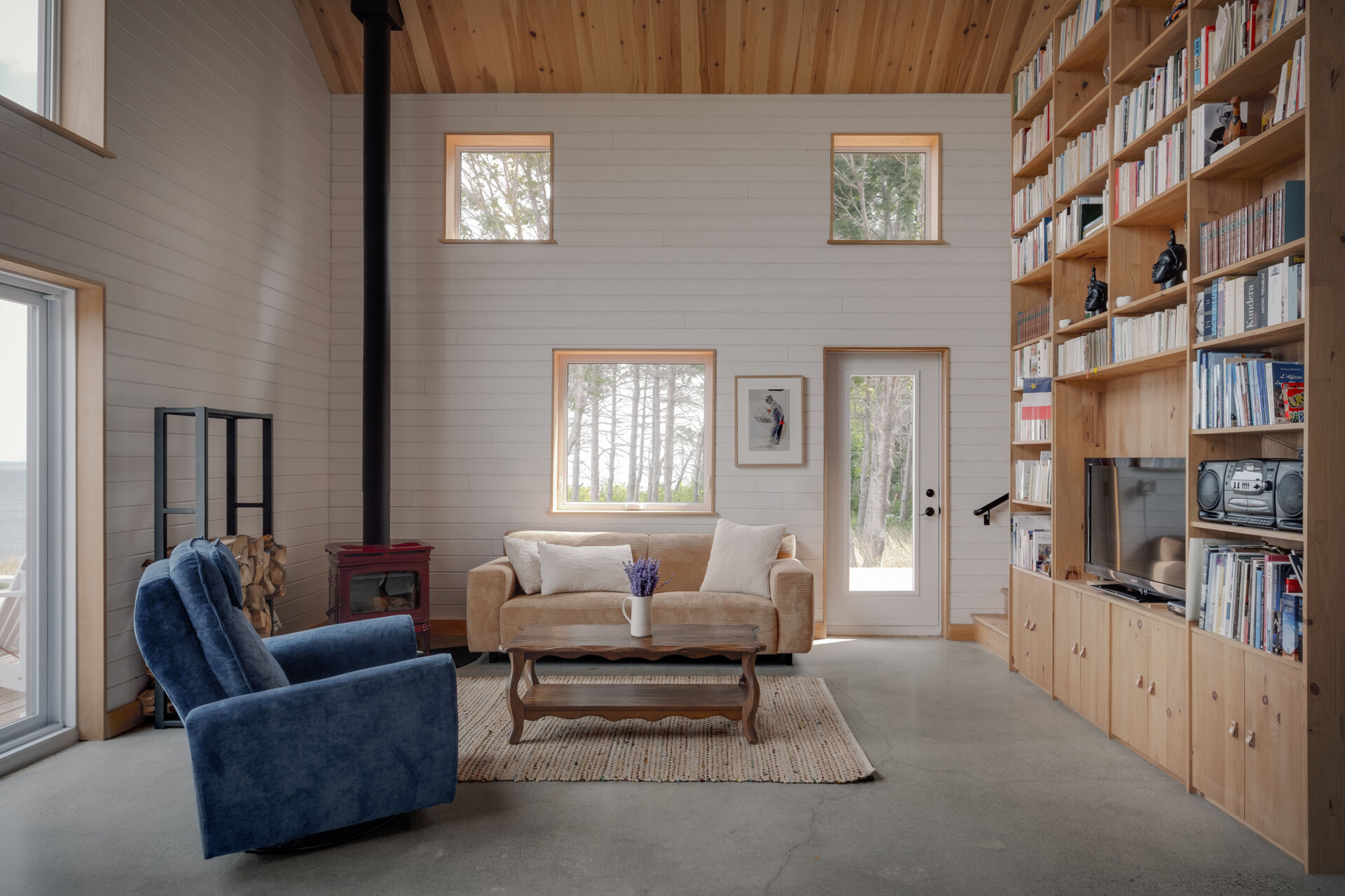 En el corazón de la casa hay una sala de estar de doble altura, lo que le da una sensación abierta y espaciosa con luz que se filtra desde arriba y a través de ambos pisos. Es el área de reunión principal donde se reúne todo. El volumen vertical le da presencia sin resultar abrumador, lo que lo hace adecuado para momentos tranquilos e interacciones familiares más numerosas.