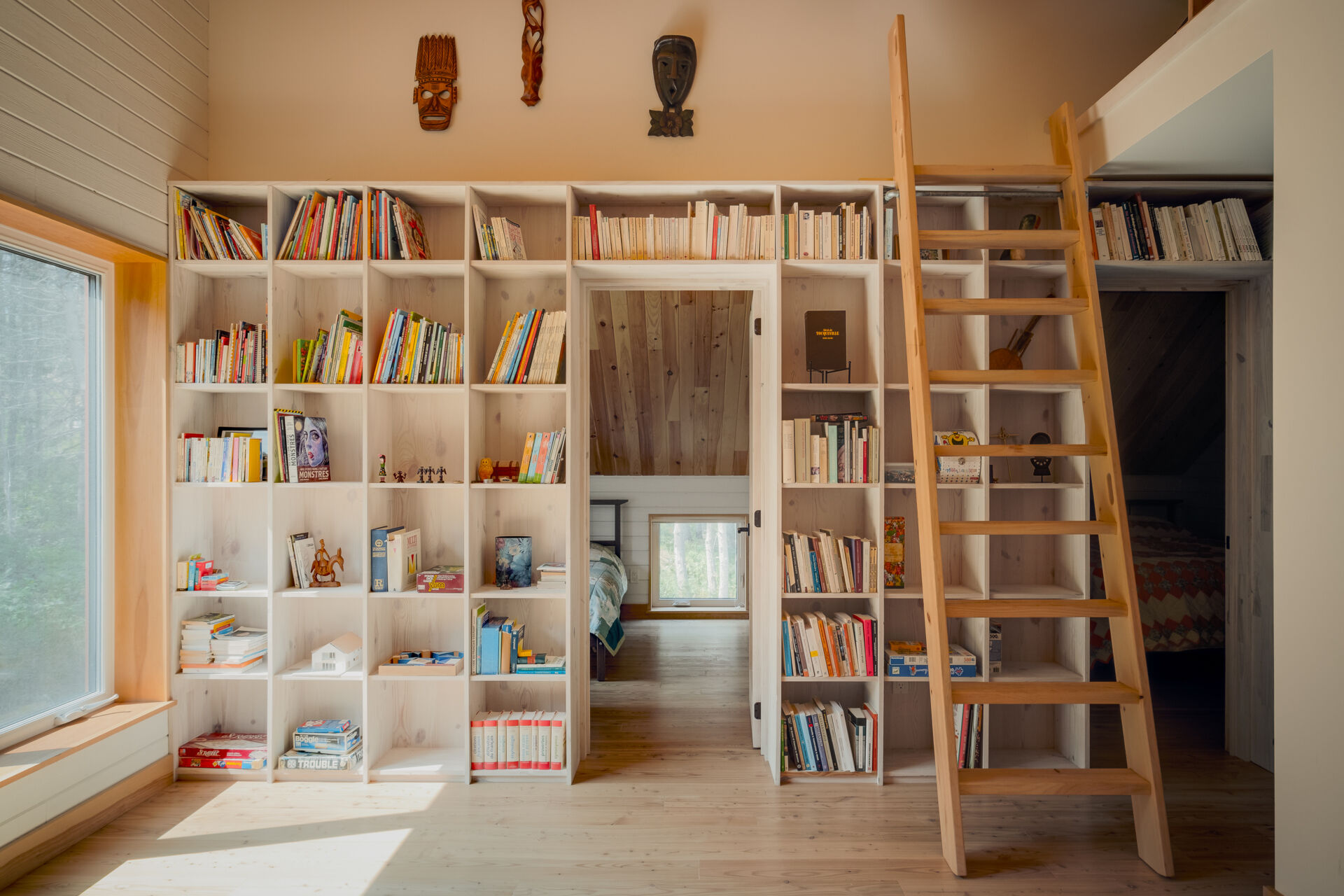 Las estanterías de pino personalizadas definen el loft, agregan calidez y crean un espacio de lectura.