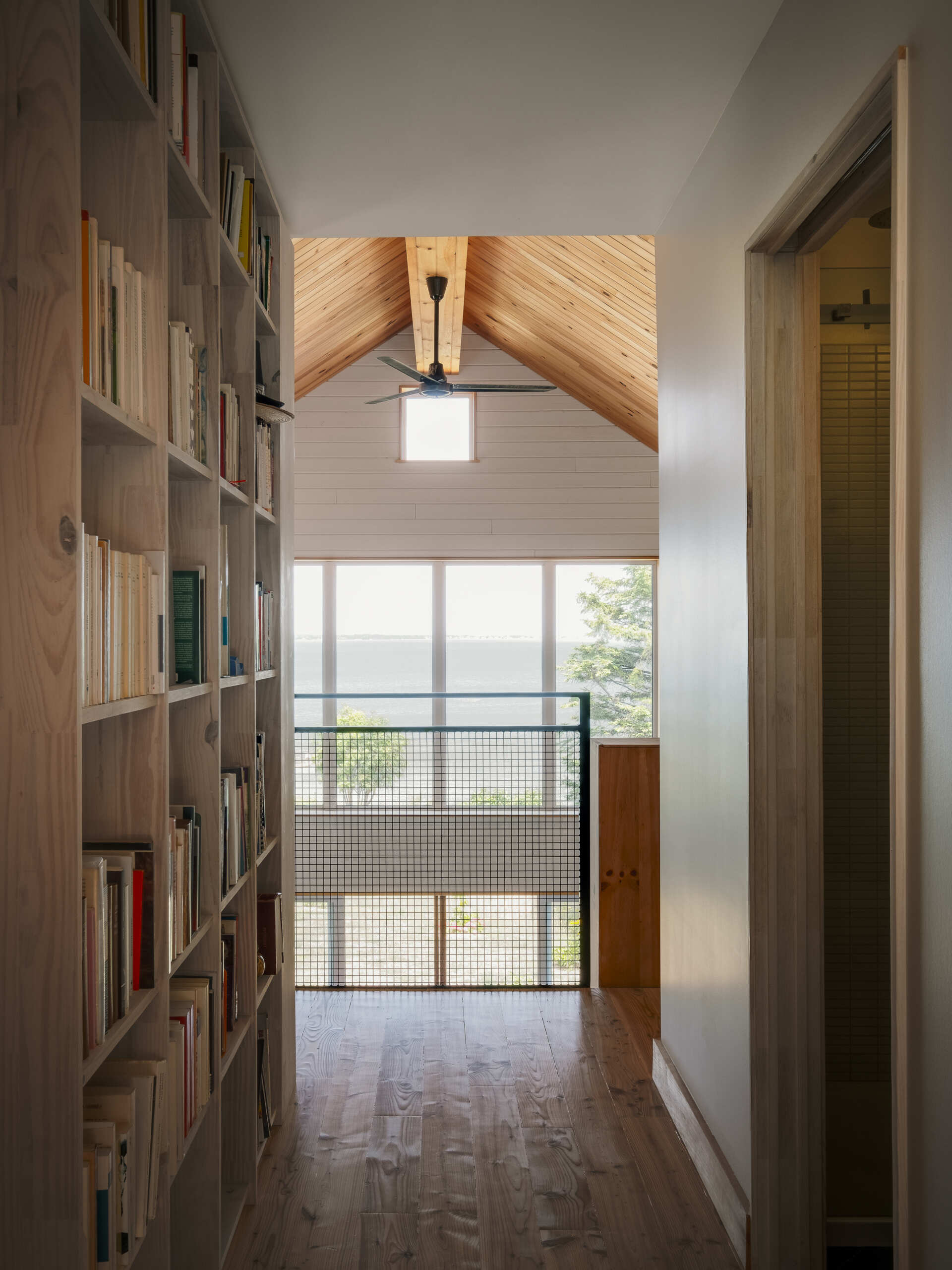 Las estanterías de pino personalizadas definen el loft, agregan calidez y crean un espacio de lectura.