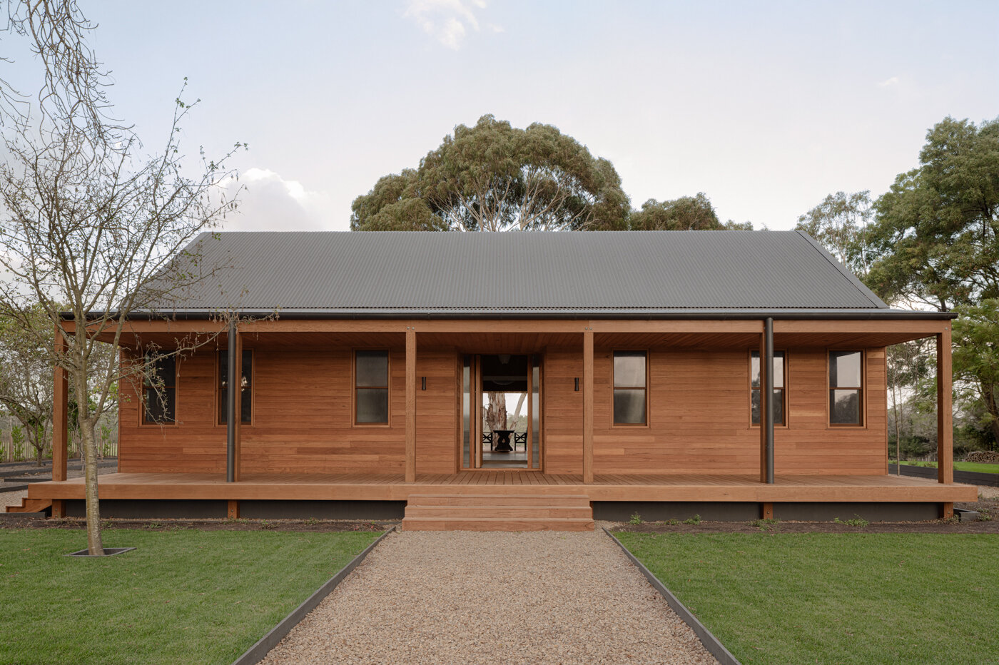 Local blackbutt timber defines the exterior of this vineyard house in Main Ridge. Designed by Porebski Architects, the two pavilion structures are clad in ship-lapped boards and raised lightly above the landscape.