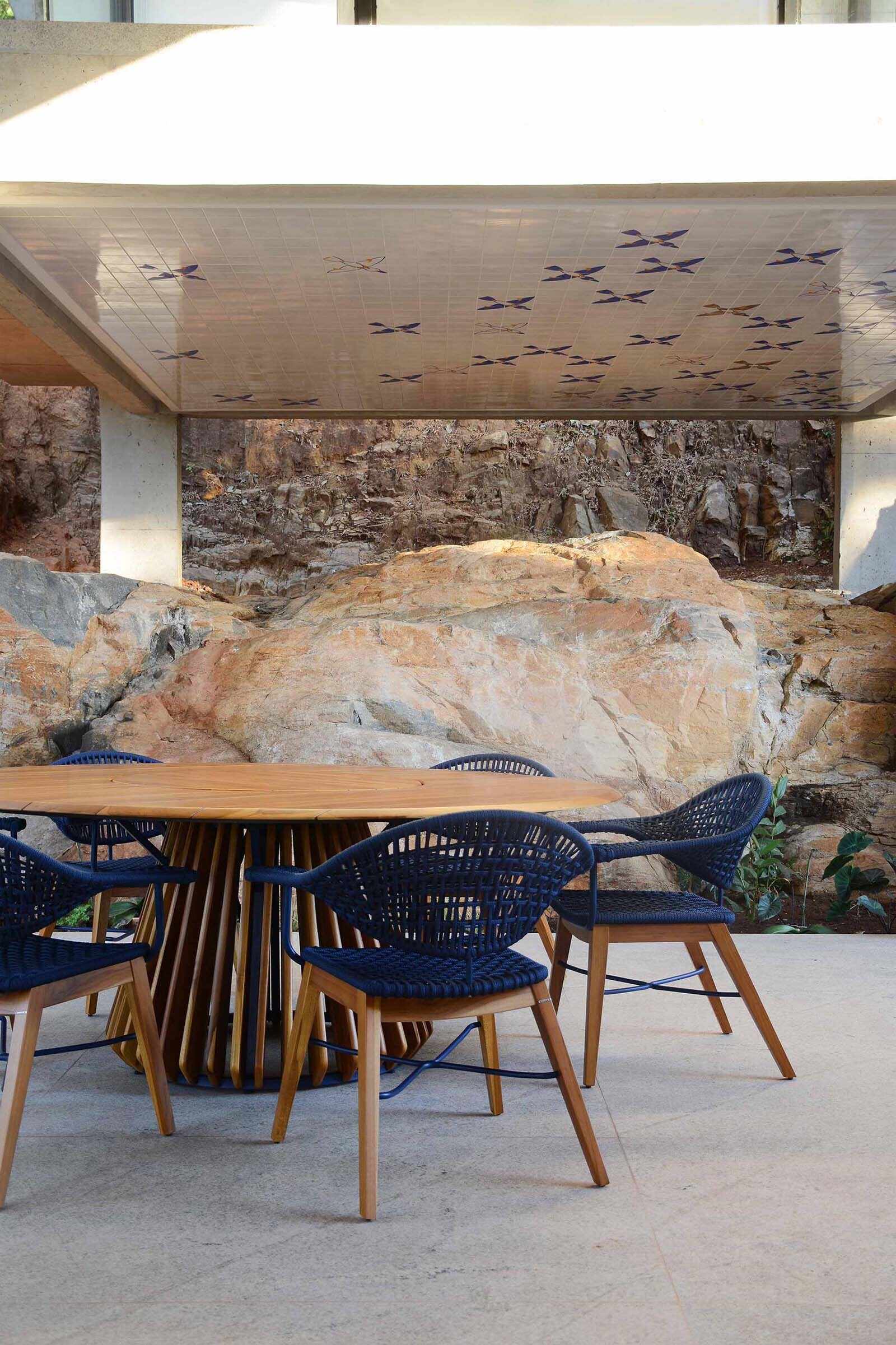 A covered patio with curved stairs extends the living space outdoors, continuing the architectural language of smooth concrete forms.