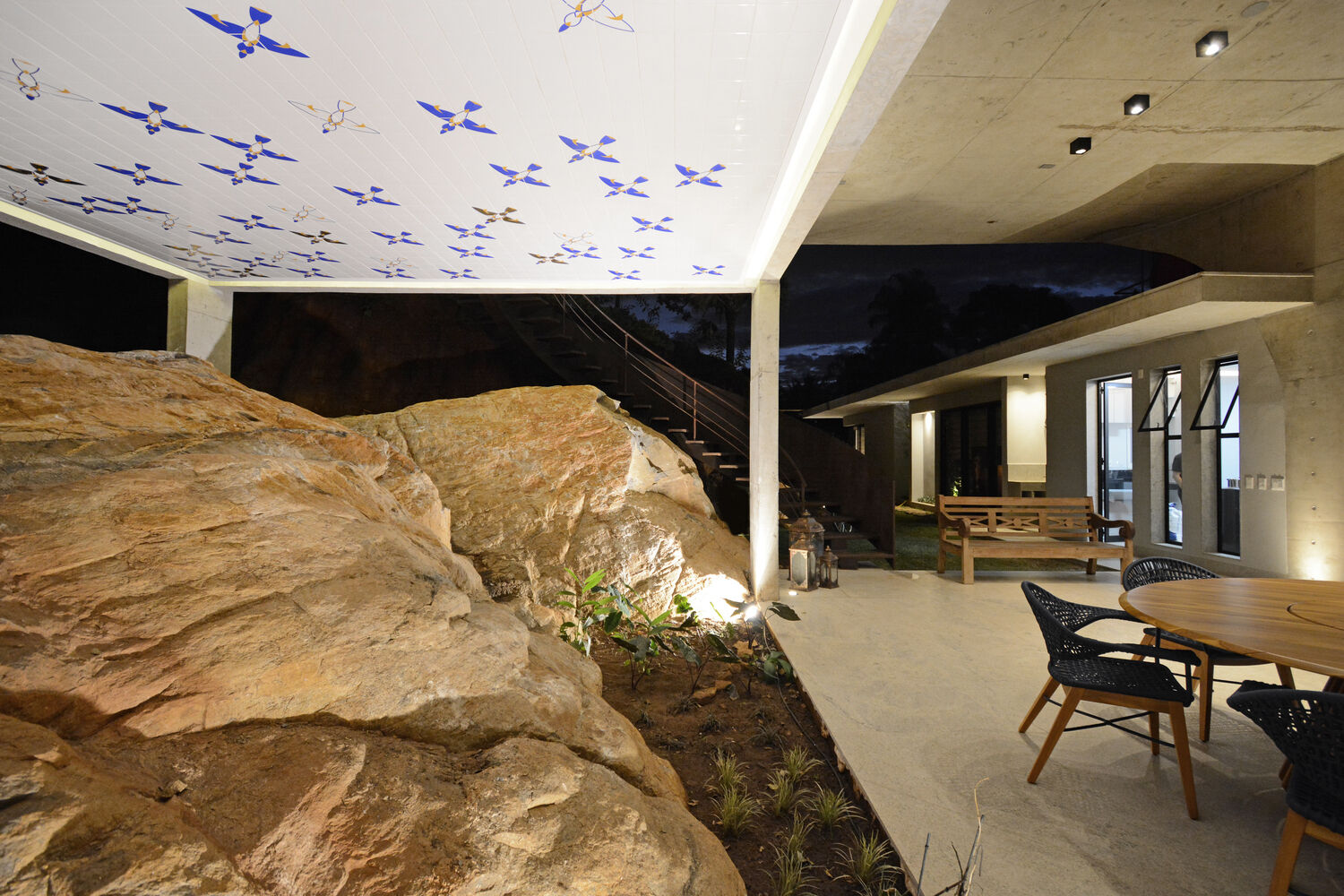 An unexpected stone wall discovered during construction became a sculptural feature of the home, adding texture, water movement, and a connection to the landscape.
