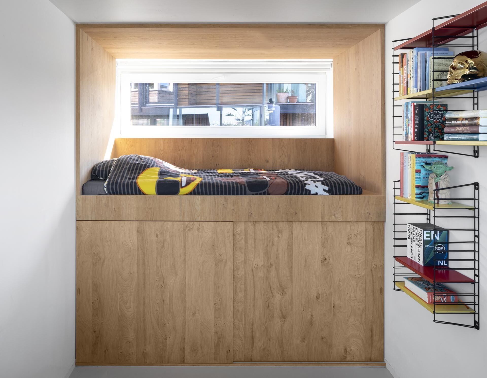 Custom loft beds and warm wood finishes shape a compact lower level designed for rest and privacy.