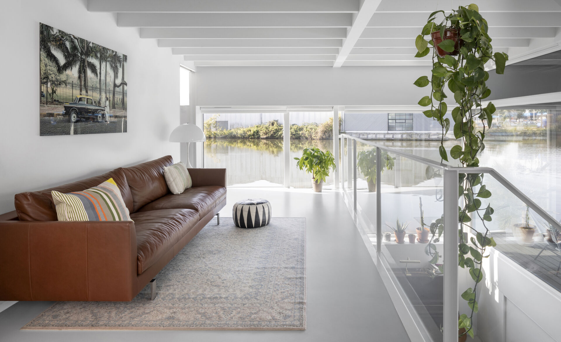 A minimal living room keeps the focus on light, structure, and views across the canal.