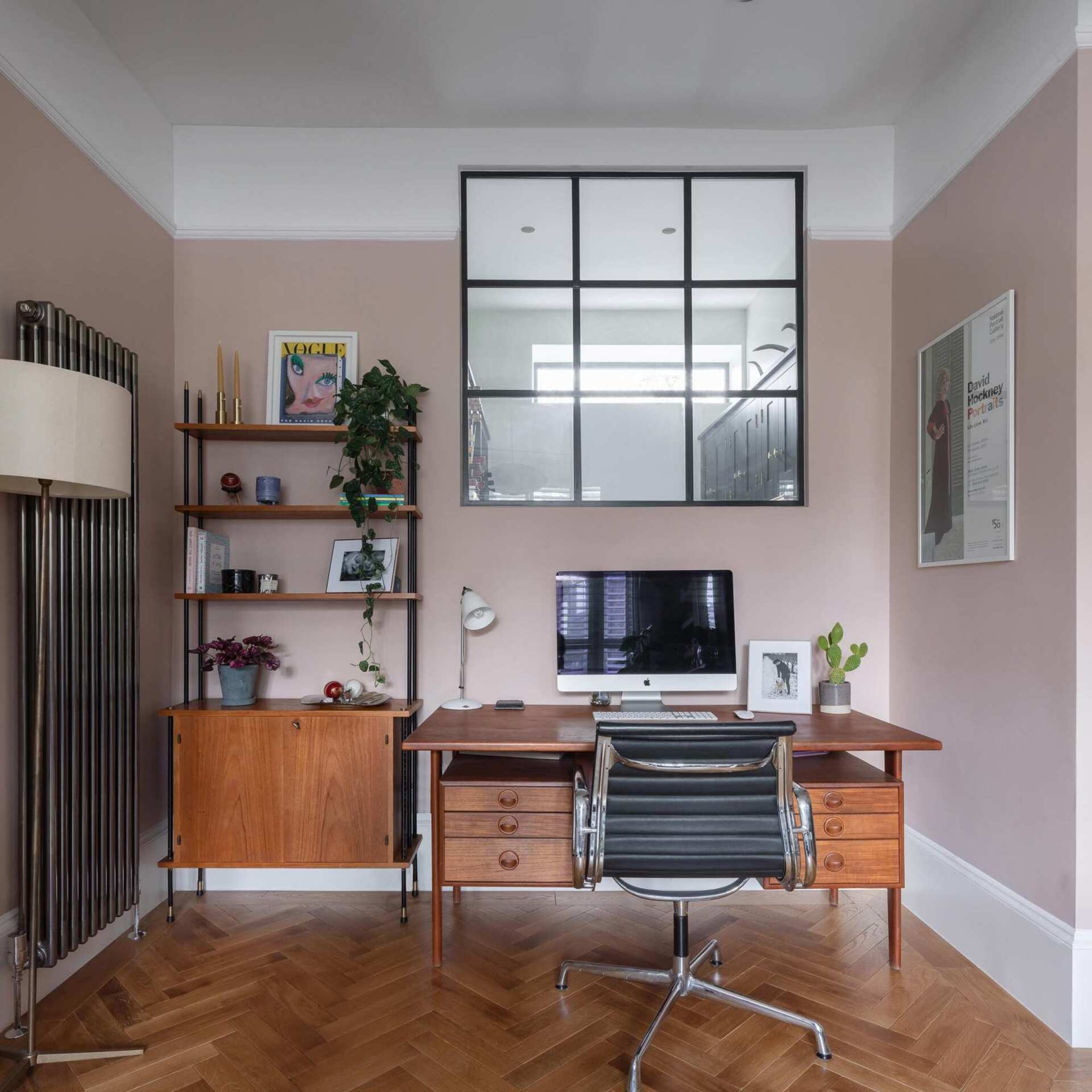 A secondary living room with a fireplace doubles as a home office, with high windows bringing light into the pantry below.
