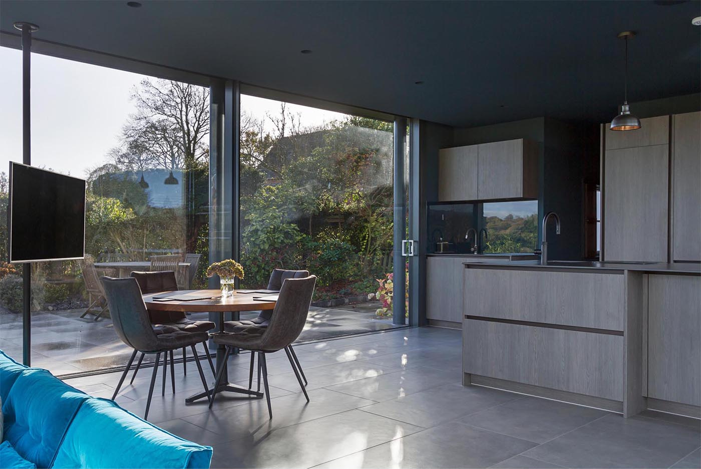 A raised dining area adds flexibility to the open-plan layout, keeping the space functional and uncluttered.
