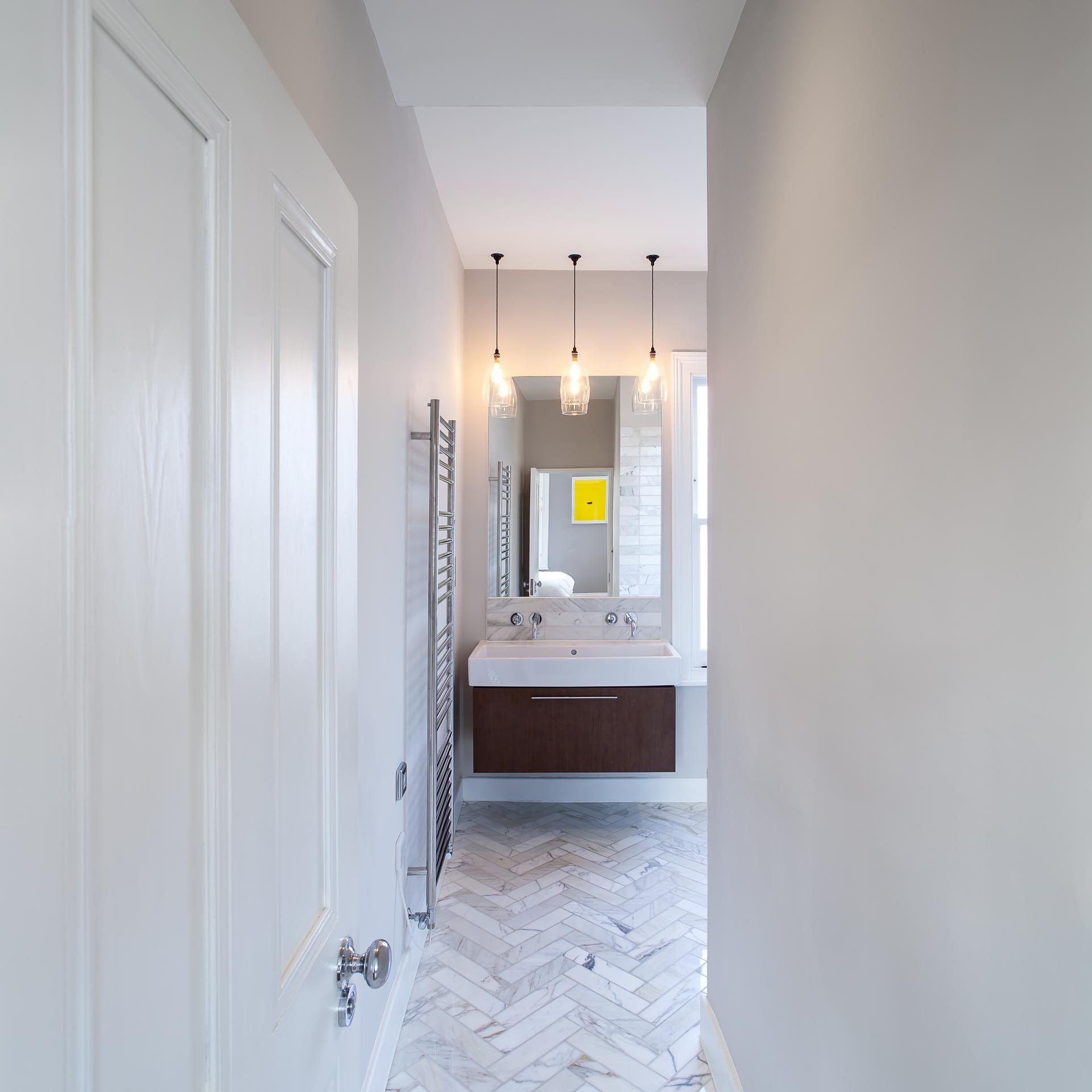 Gray stone tiles wrap the bathroom floor and walls, while three built in shower niches add practical storage.