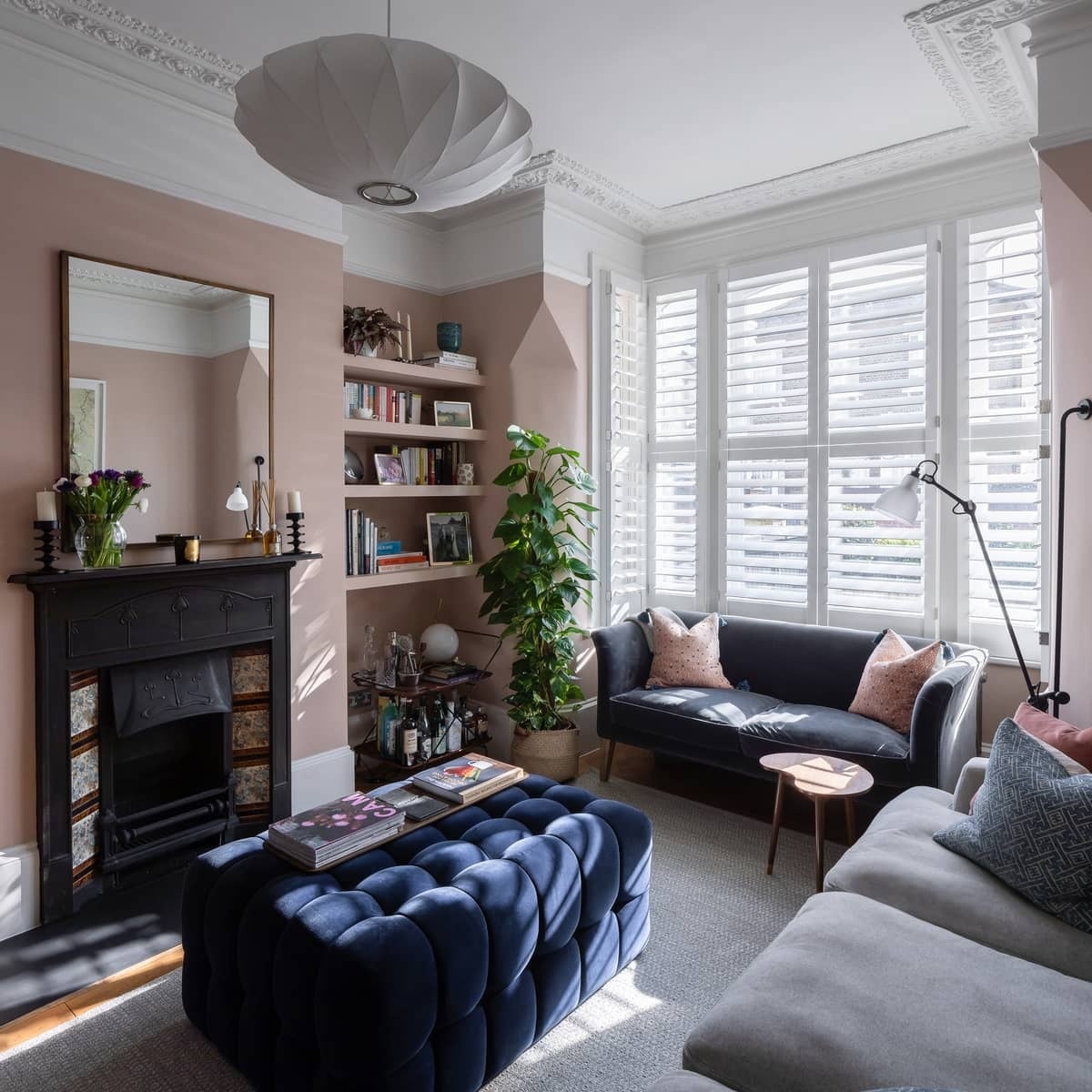 A secondary living room with a fireplace doubles as a home office, with high windows bringing light into the pantry below.