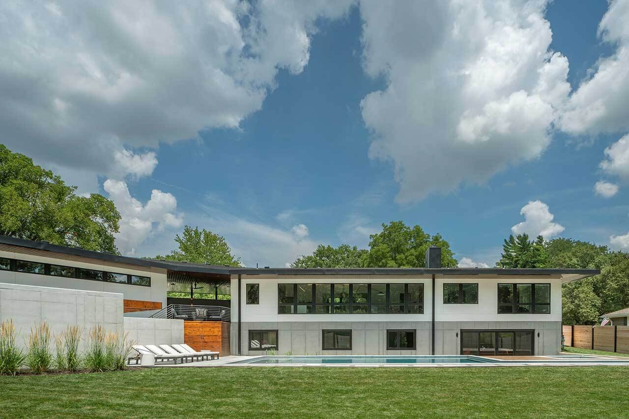 A spacious backyard includes a swimming pool, hot tub, pool house, outdoor shower, and a deck, creating a relaxing outdoor setting designed for everyday enjoyment.