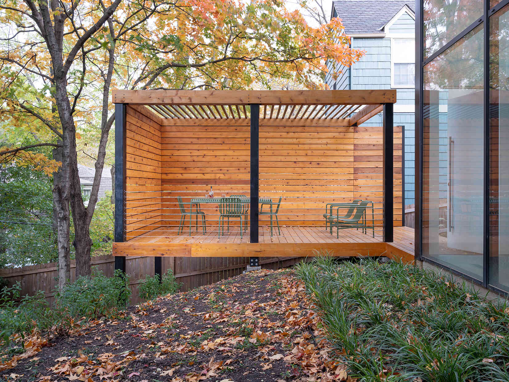 A trellis pavilion and screen wall add privacy without blocking views from inside. Positioned carefully, the deck defines the edge of the yard while still keeping sightlines open from the living spaces.