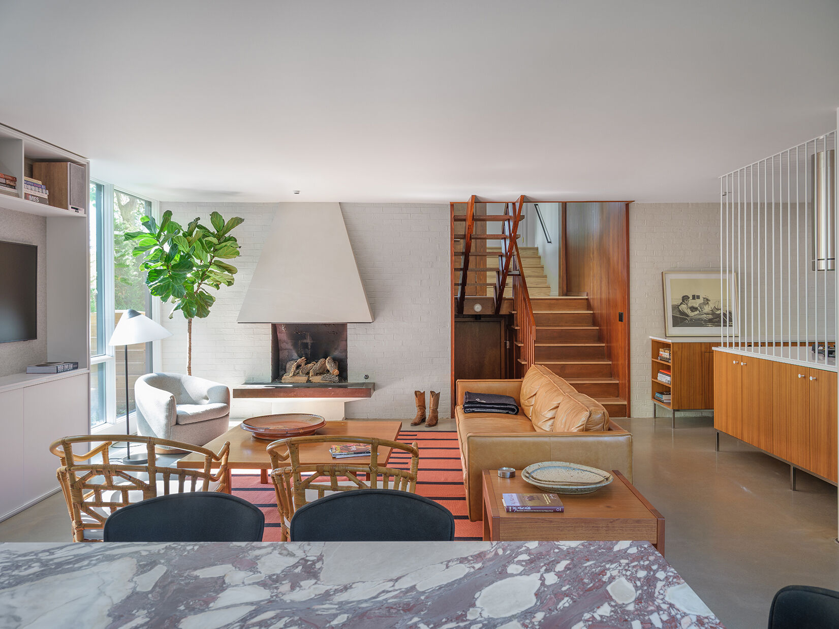 A mid-century modern living room with a fireplace, has been restored and updated to accommodate modern living.