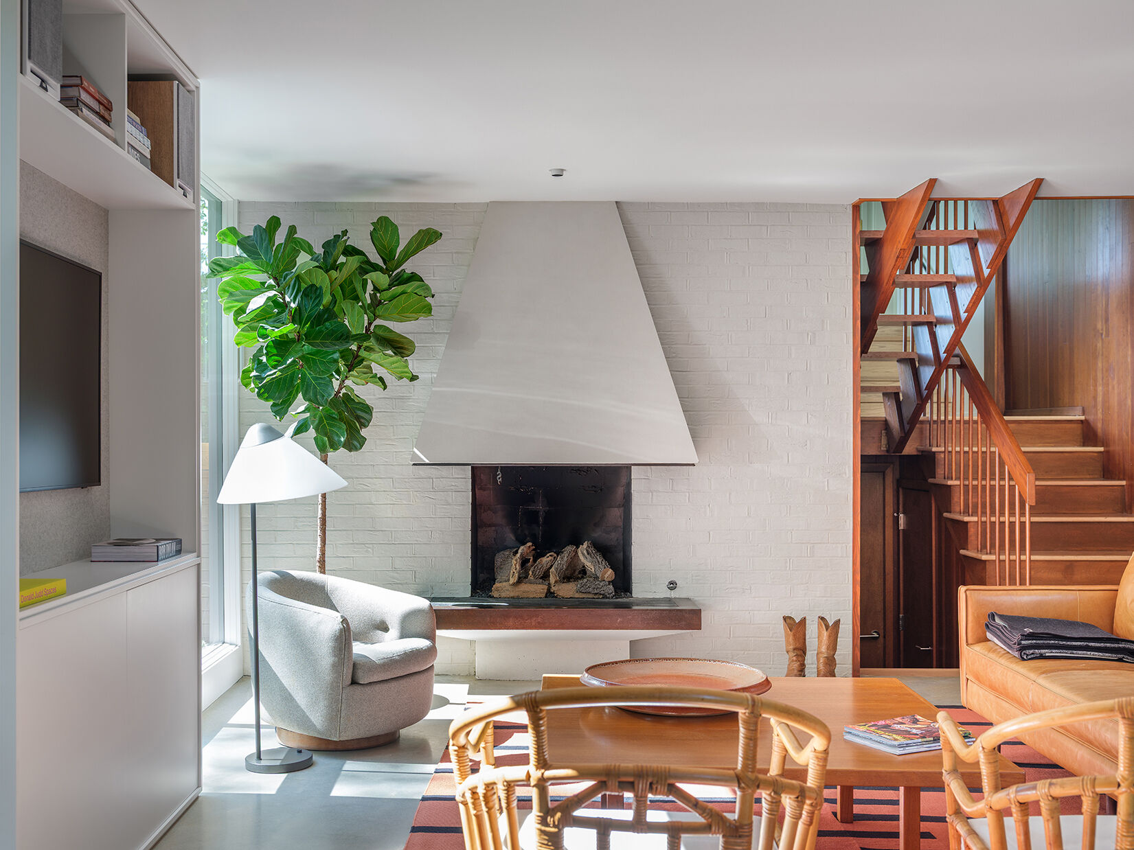A mid-century modern living room with a fireplace, has been restored and updated to accommodate modern living.