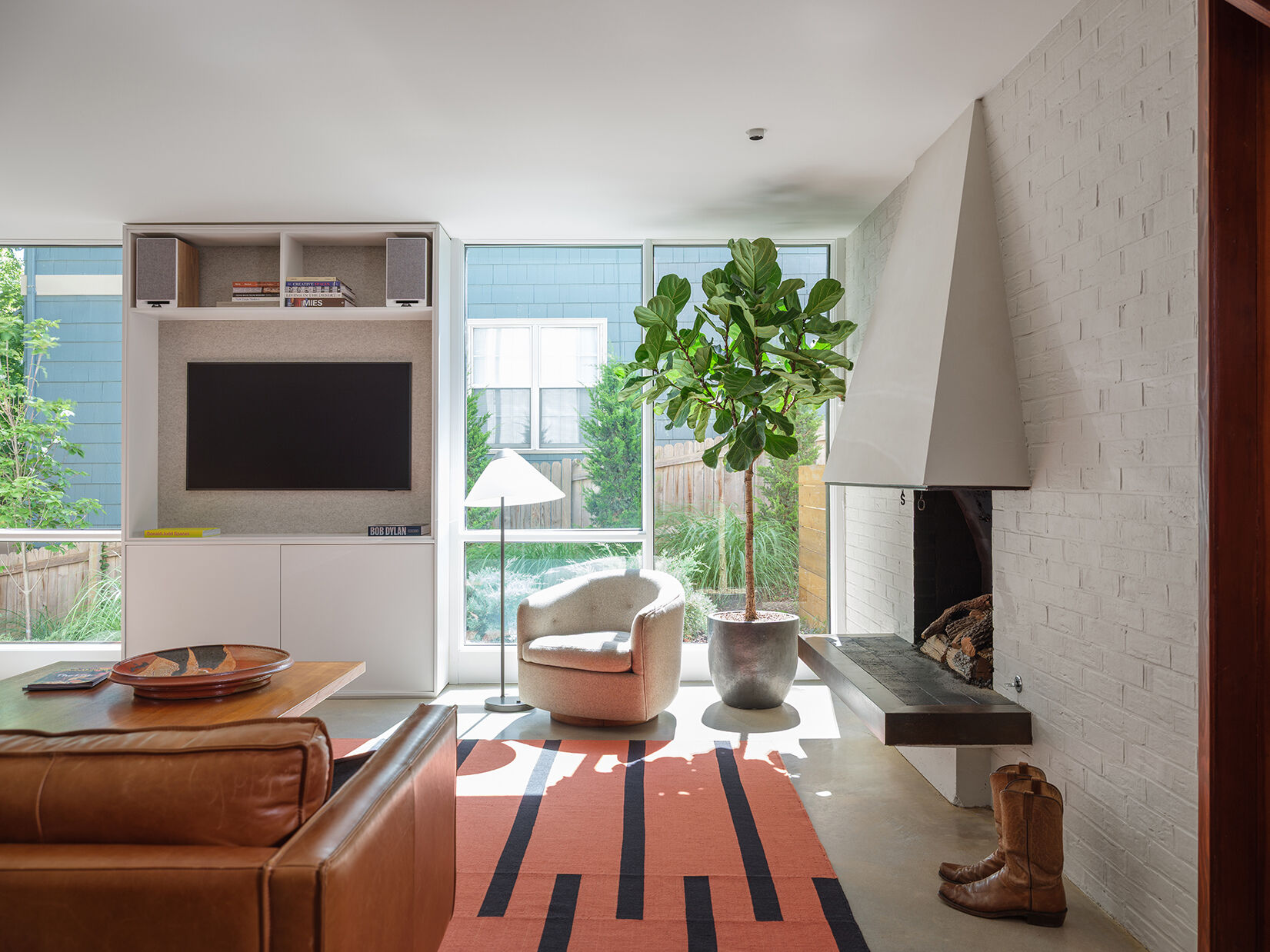 A mid-century modern living room with a fireplace, has been restored and updated to accommodate modern living.