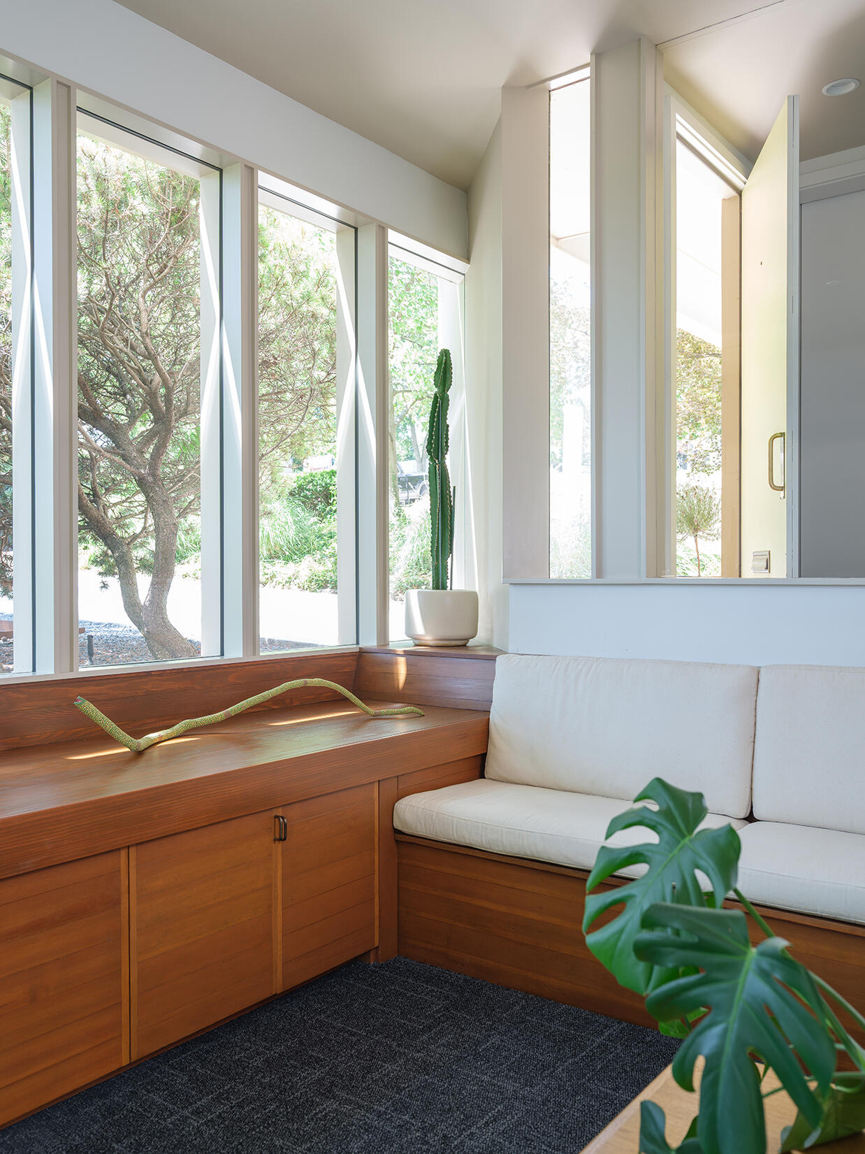 In the sitting room, restored built-ins and a rebuilt window wall bring in light while keeping the midcentury character intact.