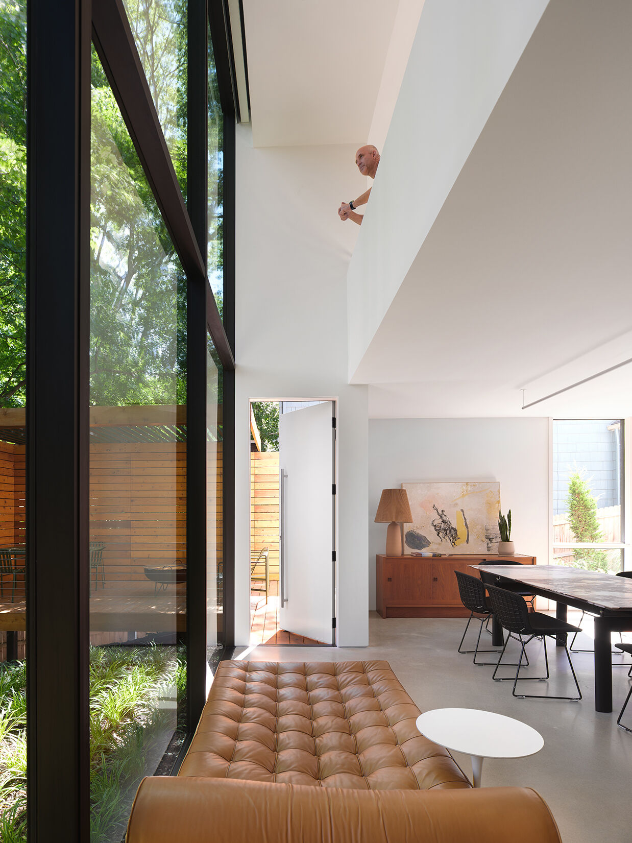 Along the rear wall, expansive glass and doors frame views of the wooded yard and draw natural light deep into the home.