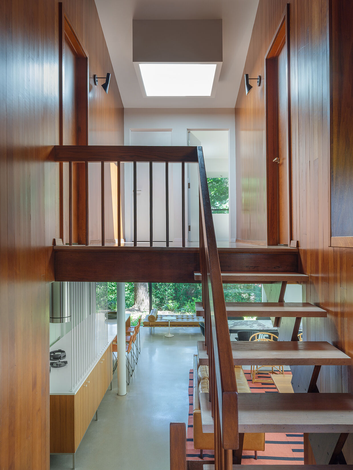 At the stairs, the original structure is restored, linking all five levels and reinforcing the home’s split-level design.