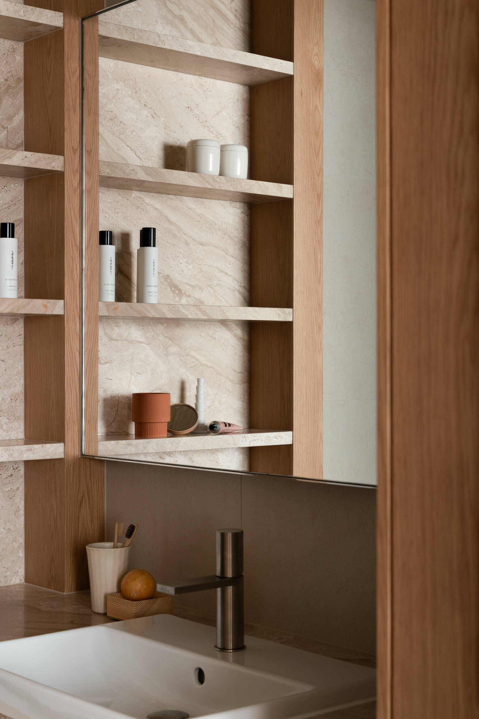 In the guest bathroom, a luminous ceiling mimics daylight, transforming a dark space into a softly glowing, serene environment.