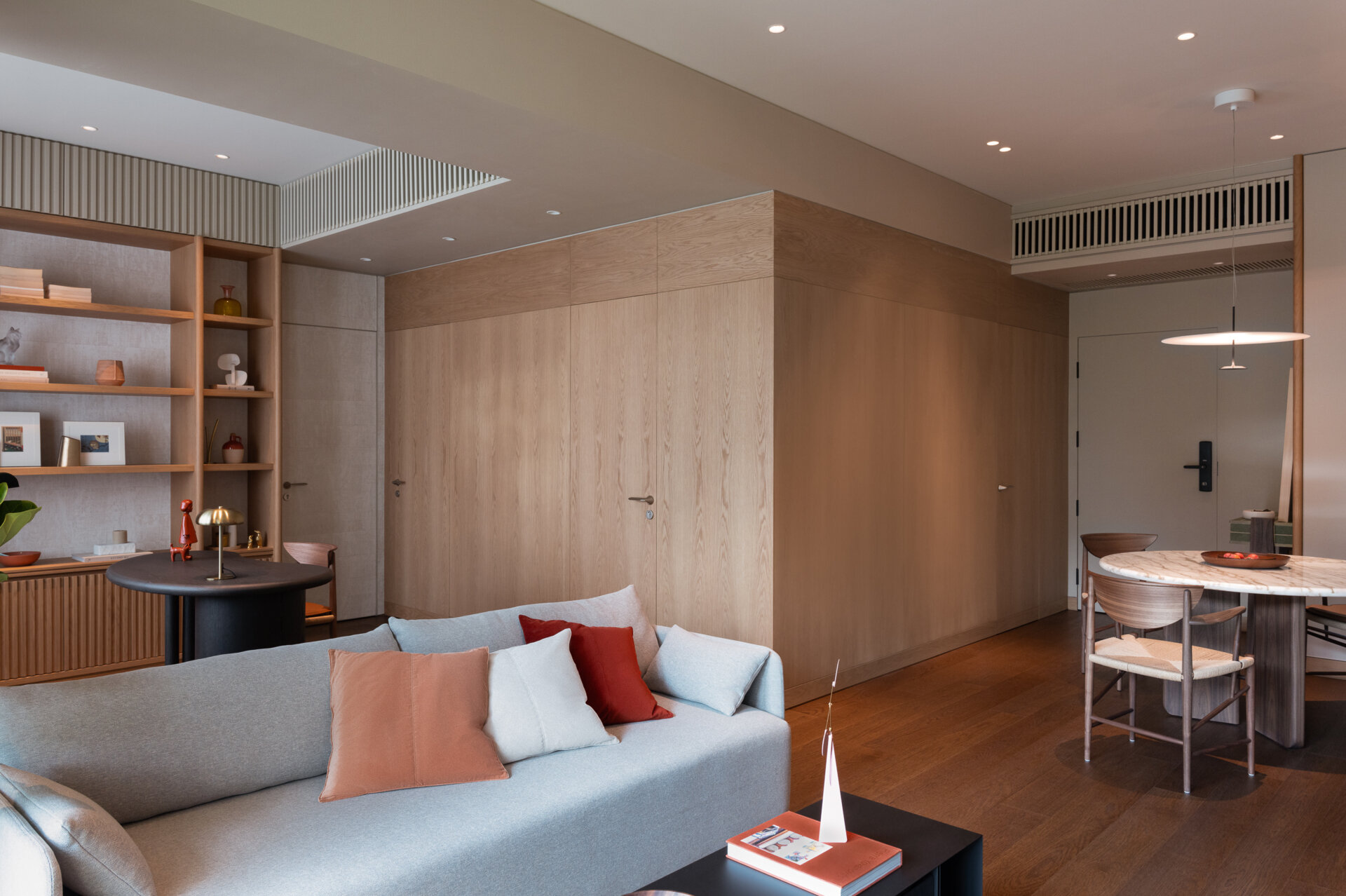 At the center of the plan sits the home’s most defining element. A “wooden box” that wraps the kitchen and bathrooms, creating a strong yet quiet anchor for circulation.