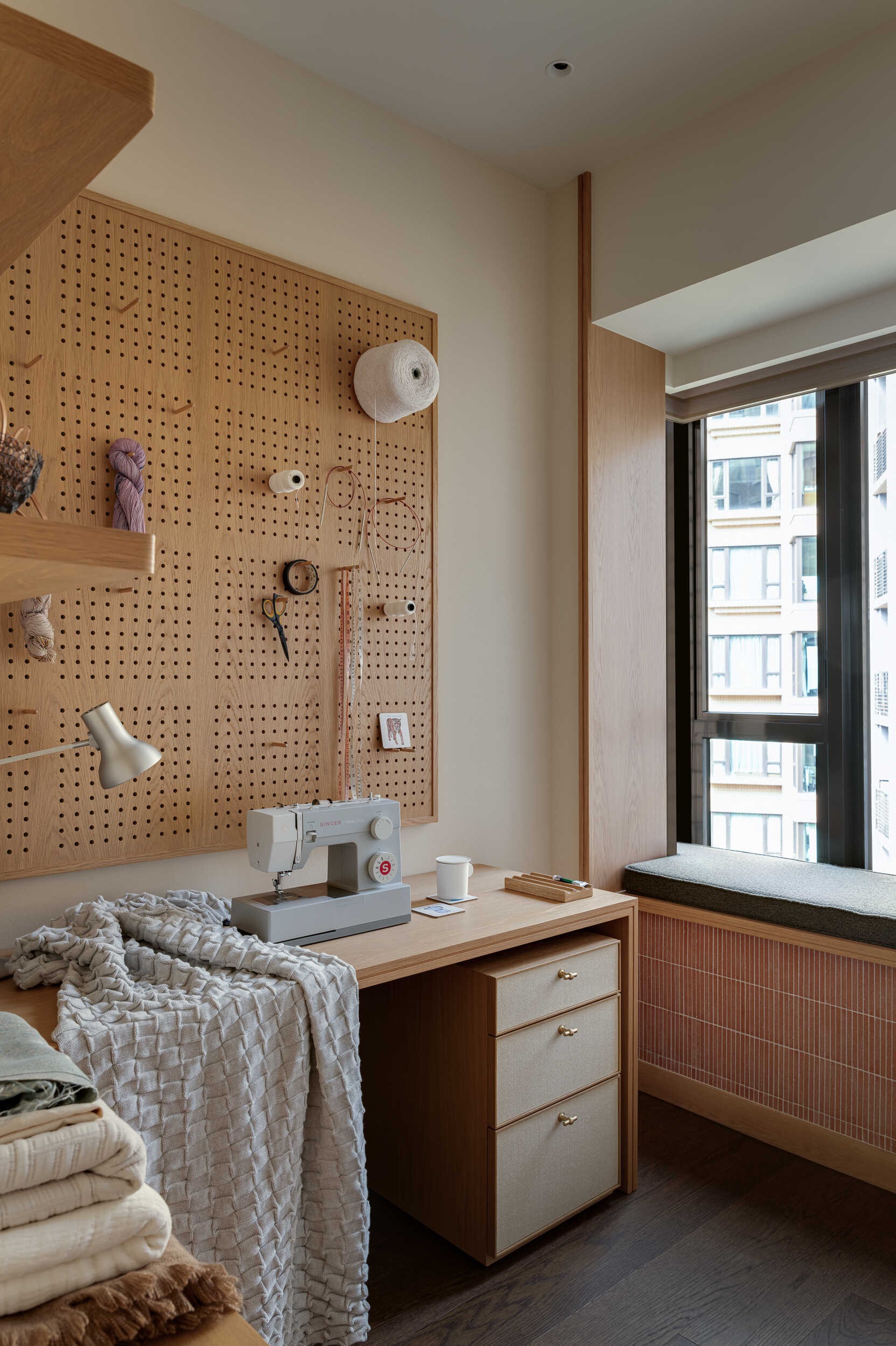 In the workshop, a compact oak workstation sits beside soft natural light, designed perfectly for sewing, knitting, and creative focus.