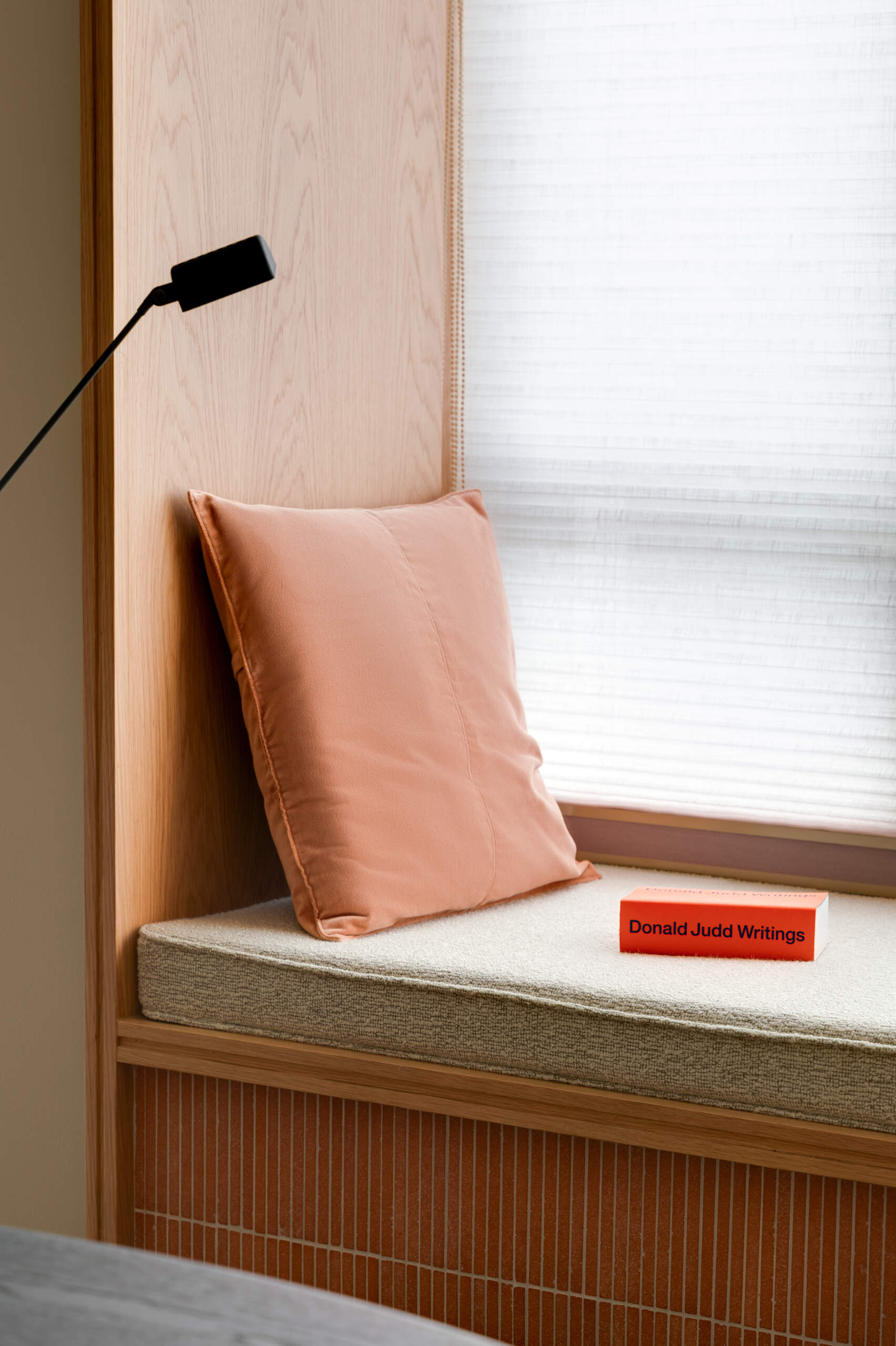 Tucked into a quieter corner, the workshop with its natural oak workstation, is positioned to catch soft sidelight from the bay window, which has been updated with terracotta tile sills and cushioned seating. 