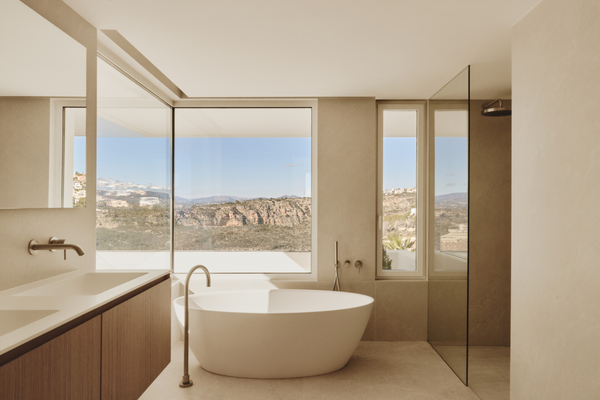 Stone surfaces and natural light create a calm bathroom environment that reflects the home's restrained material language.