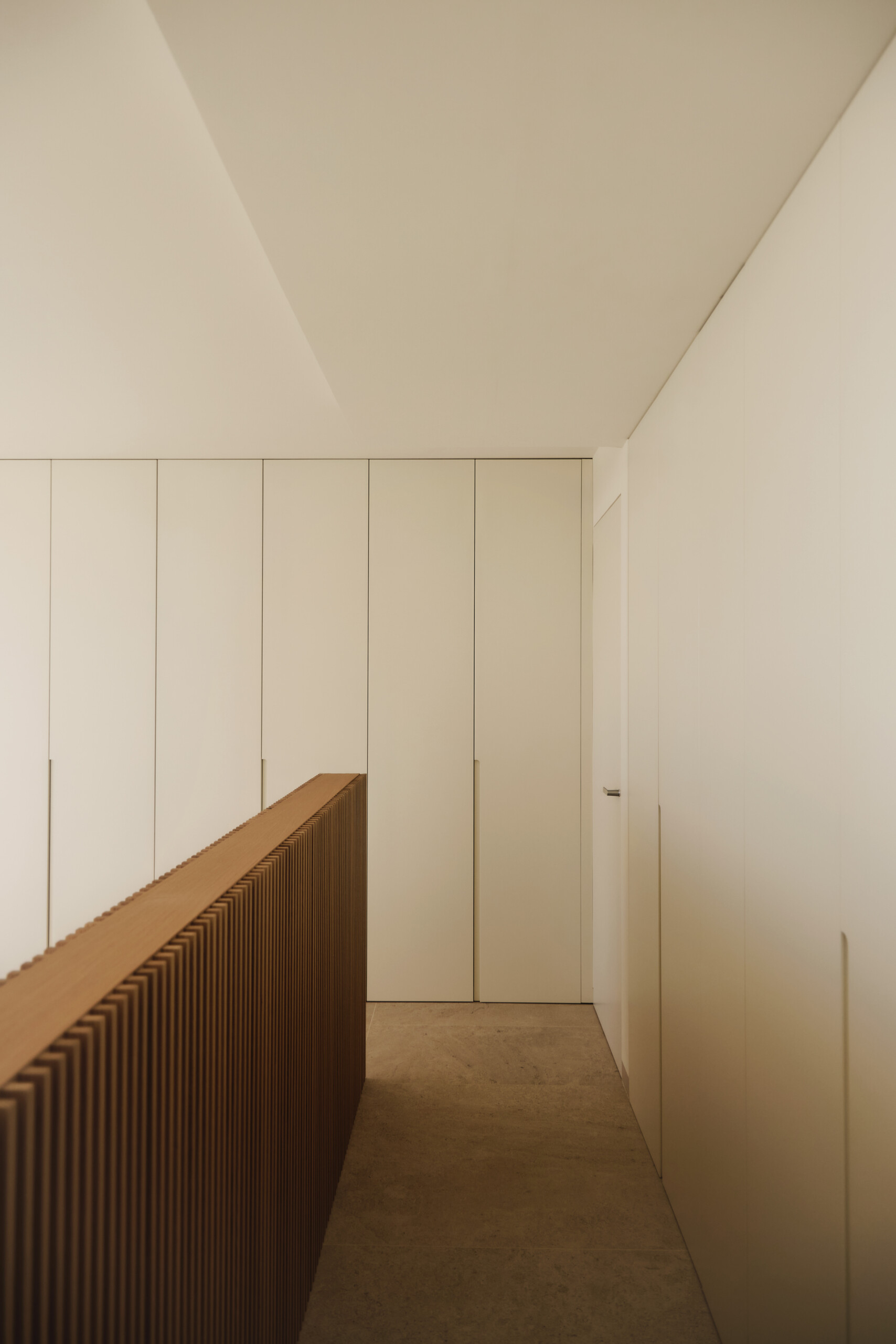 In this bedroom, the bed is positioned in the center of the room, with the headboard creating a path around the room to access the built-in closets.