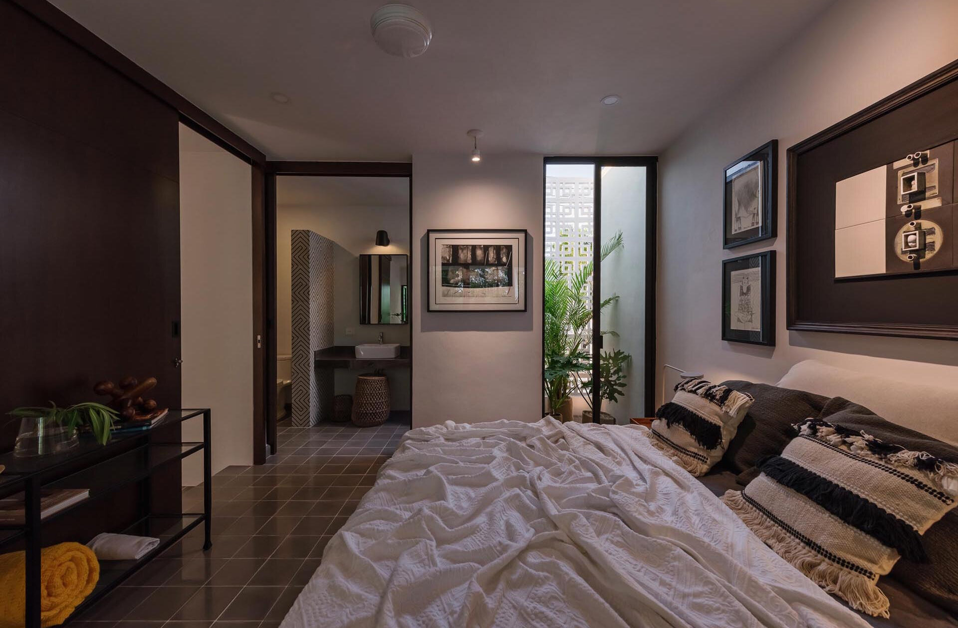 A mezzanine bedroom overlooks the double height living space and opens to a tiny planted garden, creating a calm and light filled retreat.