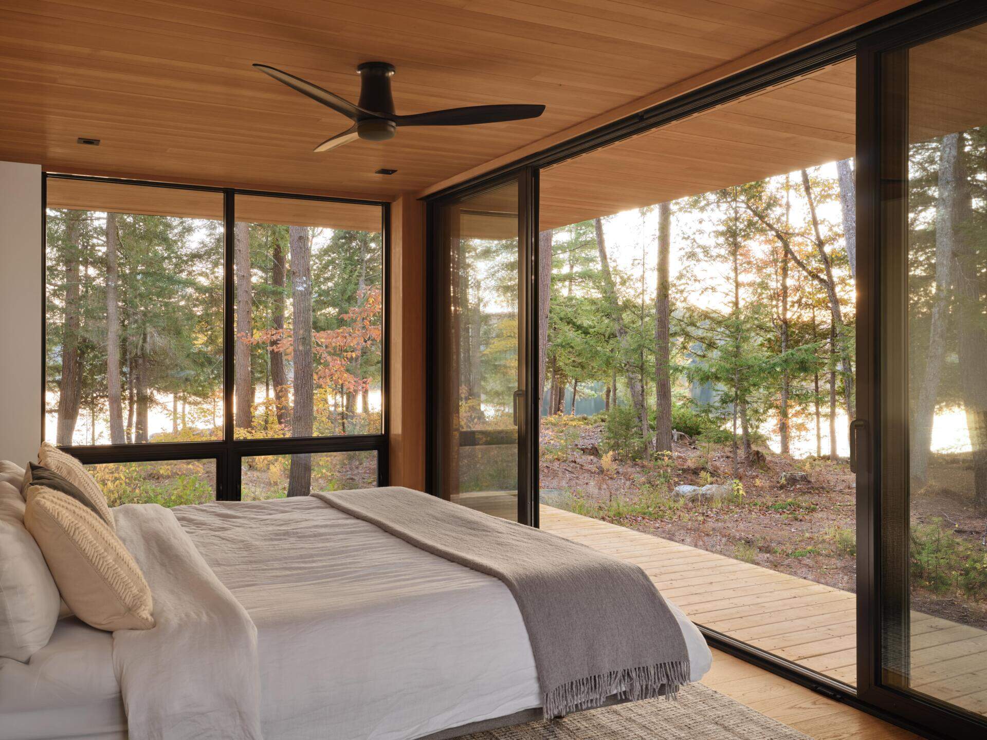A west-facing bedroom that opens completely to the outdoors, paired with an ensuite featuring an outdoor shower for a simple, nature-focused experience.