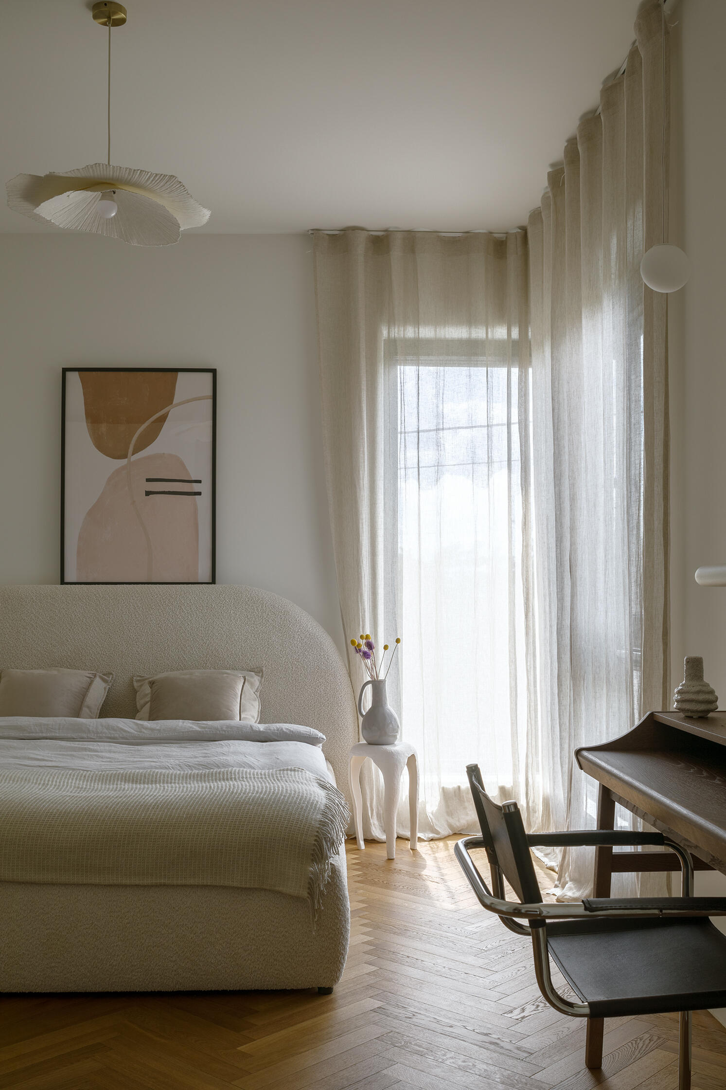 A serene bedroom with soft tones and gentle forms designed to create a calm, grounded atmosphere.