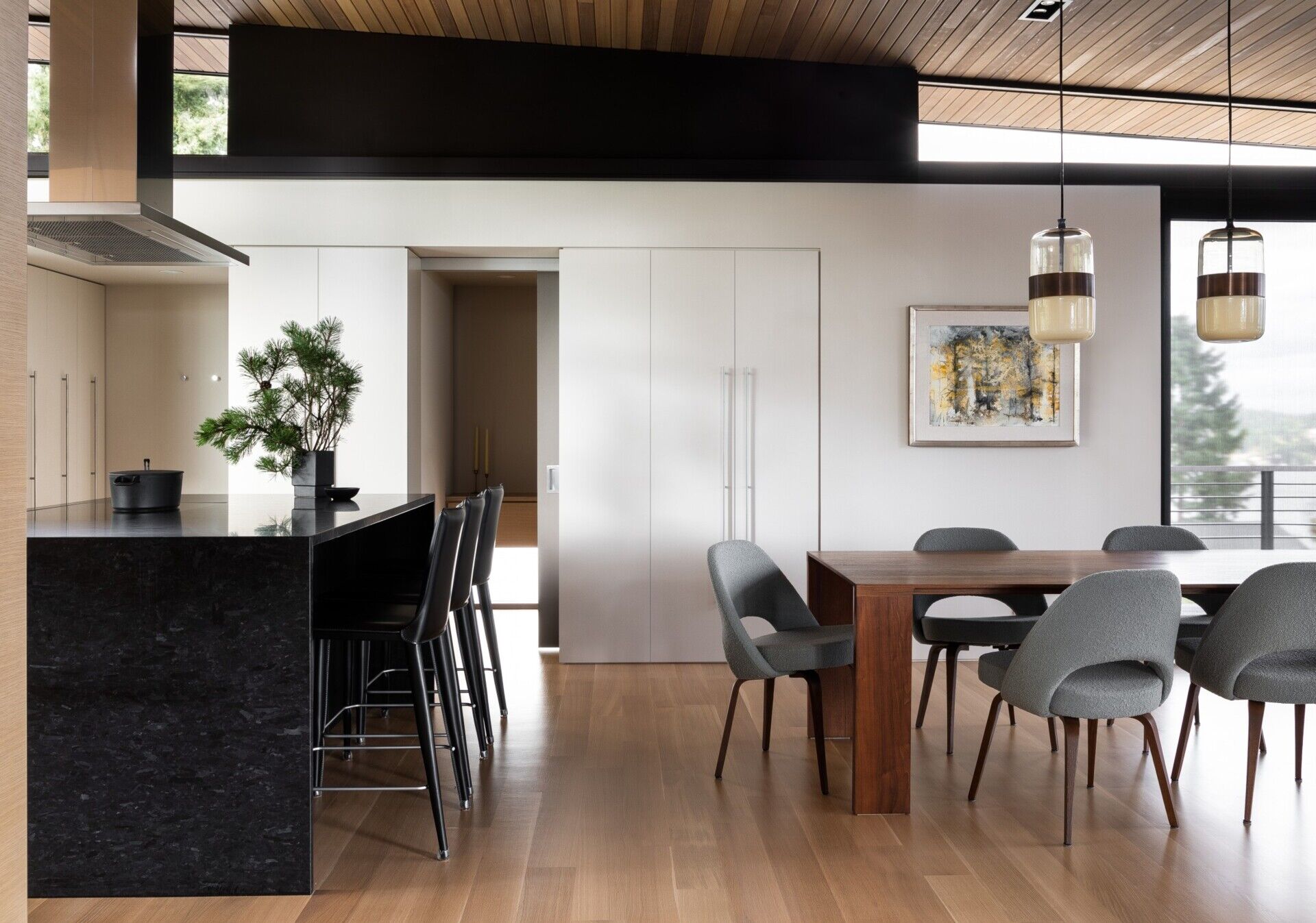 A modern kitchen with a black island and a mix of white and wood cabinetry for a clean, balanced look.
