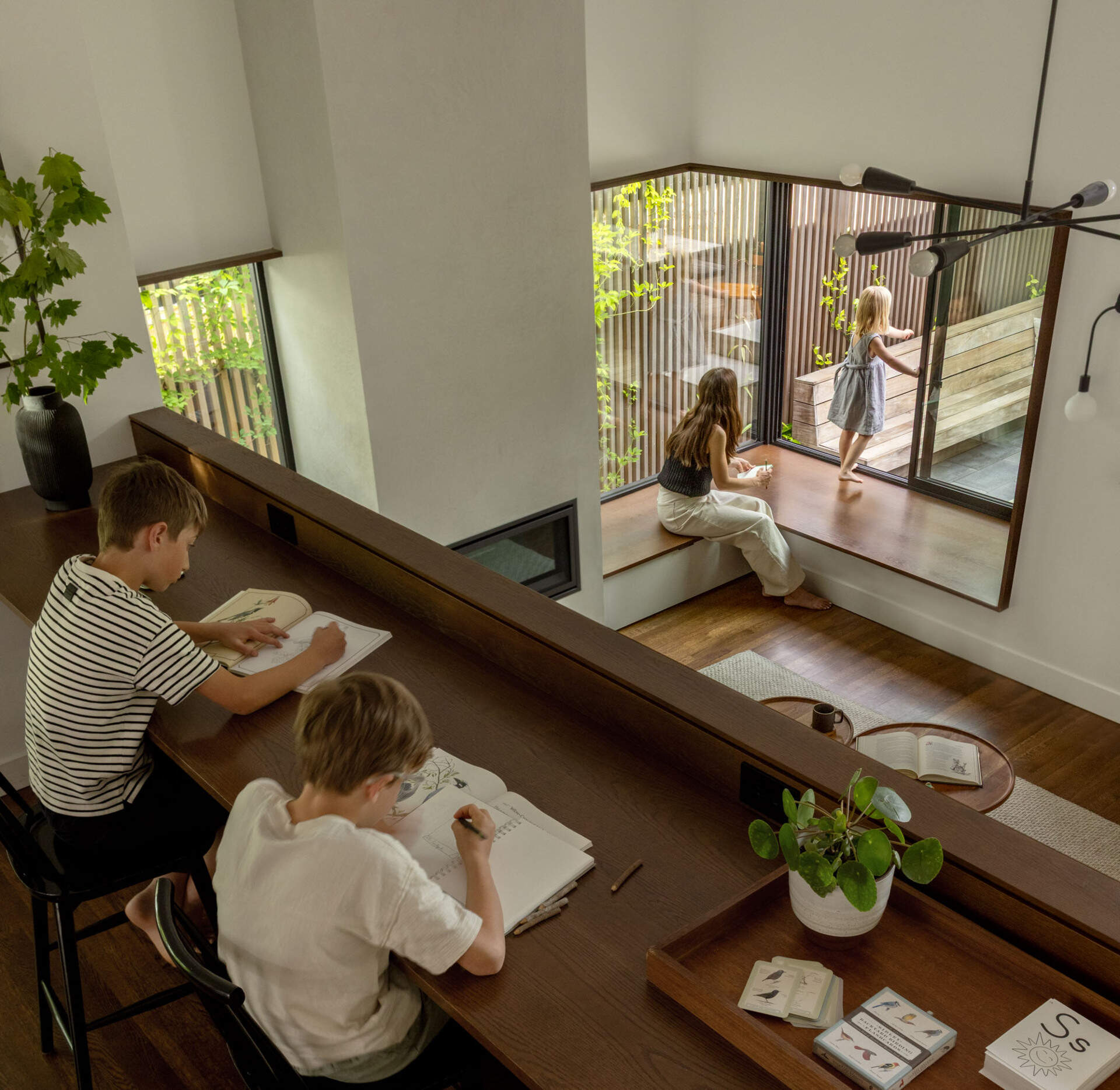 A built-in oak workbench and bookshelf create a functional transition point between the original house and the new addition.