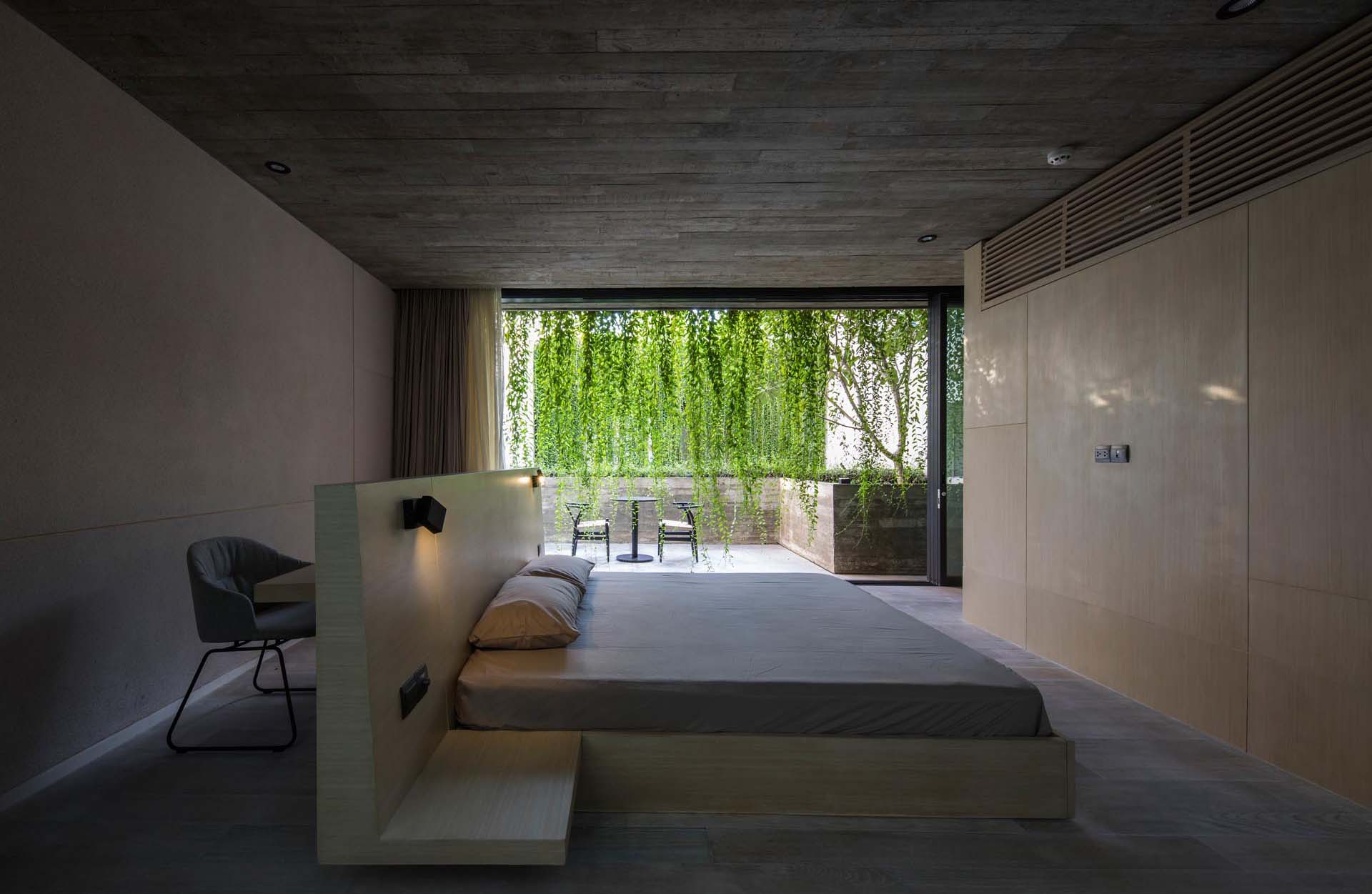 Una estructura de cama personalizada con un escritorio incorporado detrás de la cabecera convierte un dormitorio en un espacio funcional y eficiente sin agregar muebles adicionales.