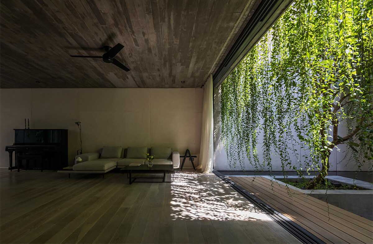 Un sistema de persianas enrollables permite que esta casa de Saigón se abra a los callejones circundantes en los días soleados y se cierre para protegerse cuando llueve, manteniendo la casa conectada a la vida de la ciudad.