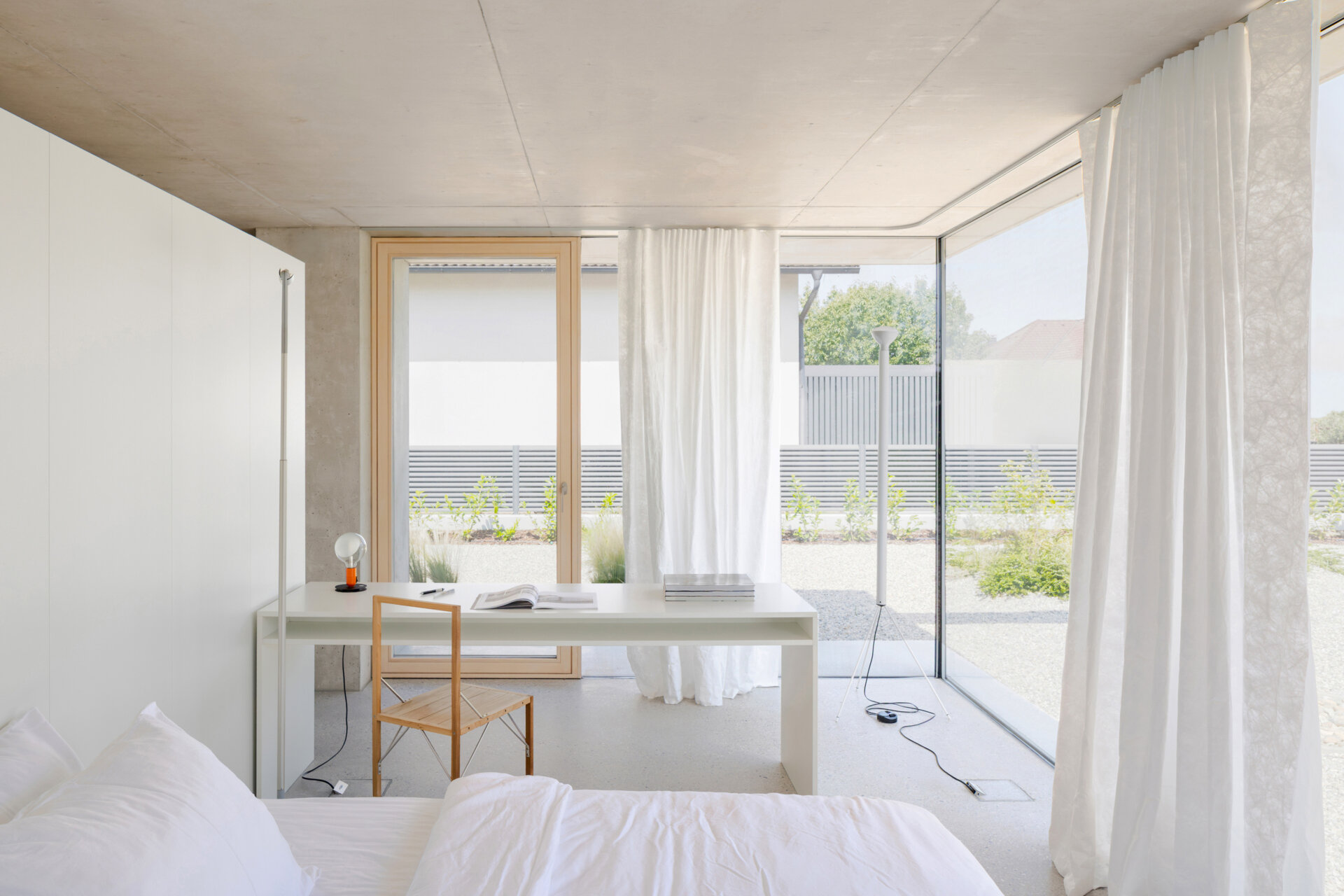 Sleeping and working spaces face a more intimate north east garden. The orientation creates a quieter atmosphere without breaking the openness of the plan. The bathroom is integrated within one of the concrete cores, with mirrored surfaces making the room feel larger.